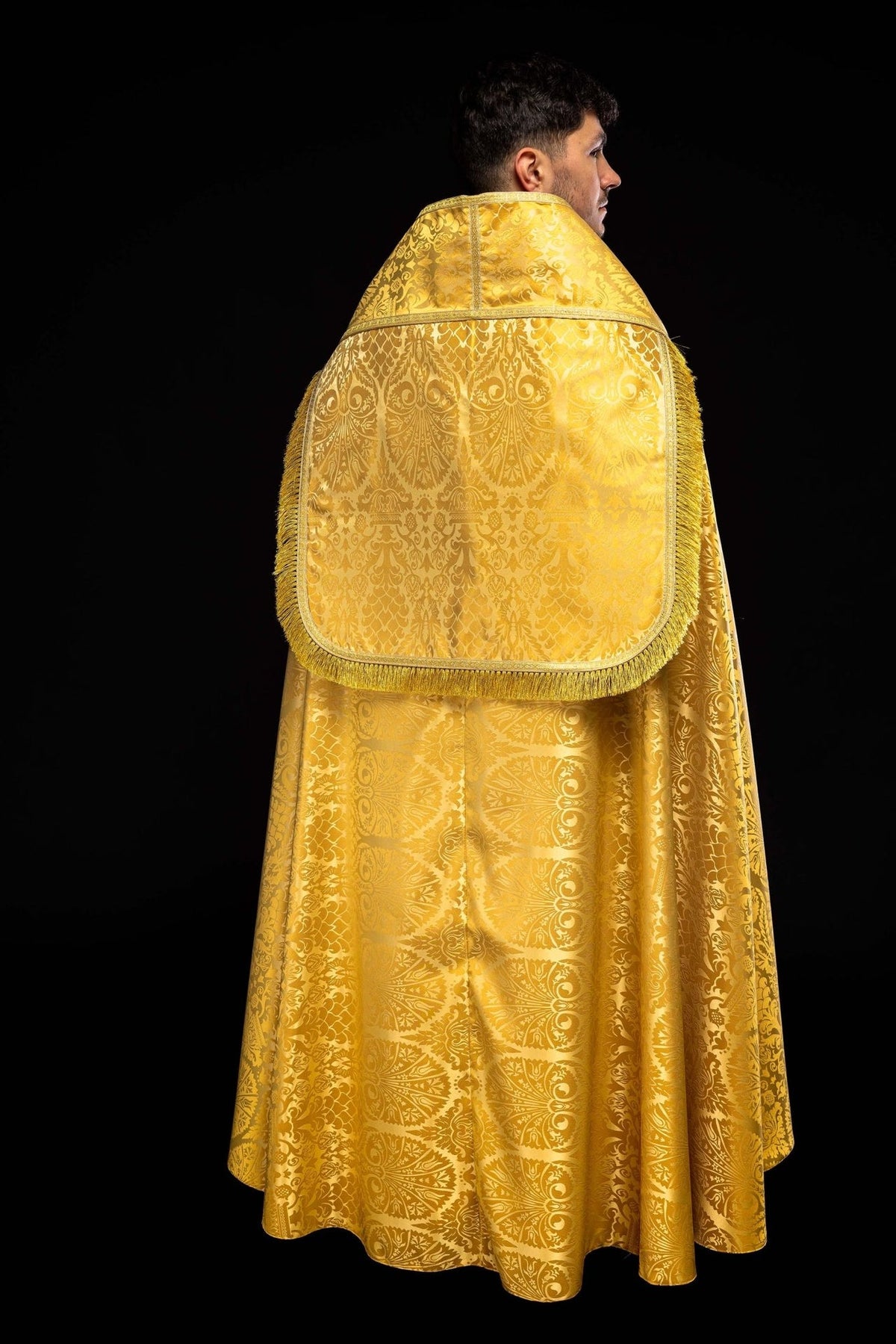 Plain Roman Jacquard Cope back view in gold jacquard with rounded flap, trim and fringe