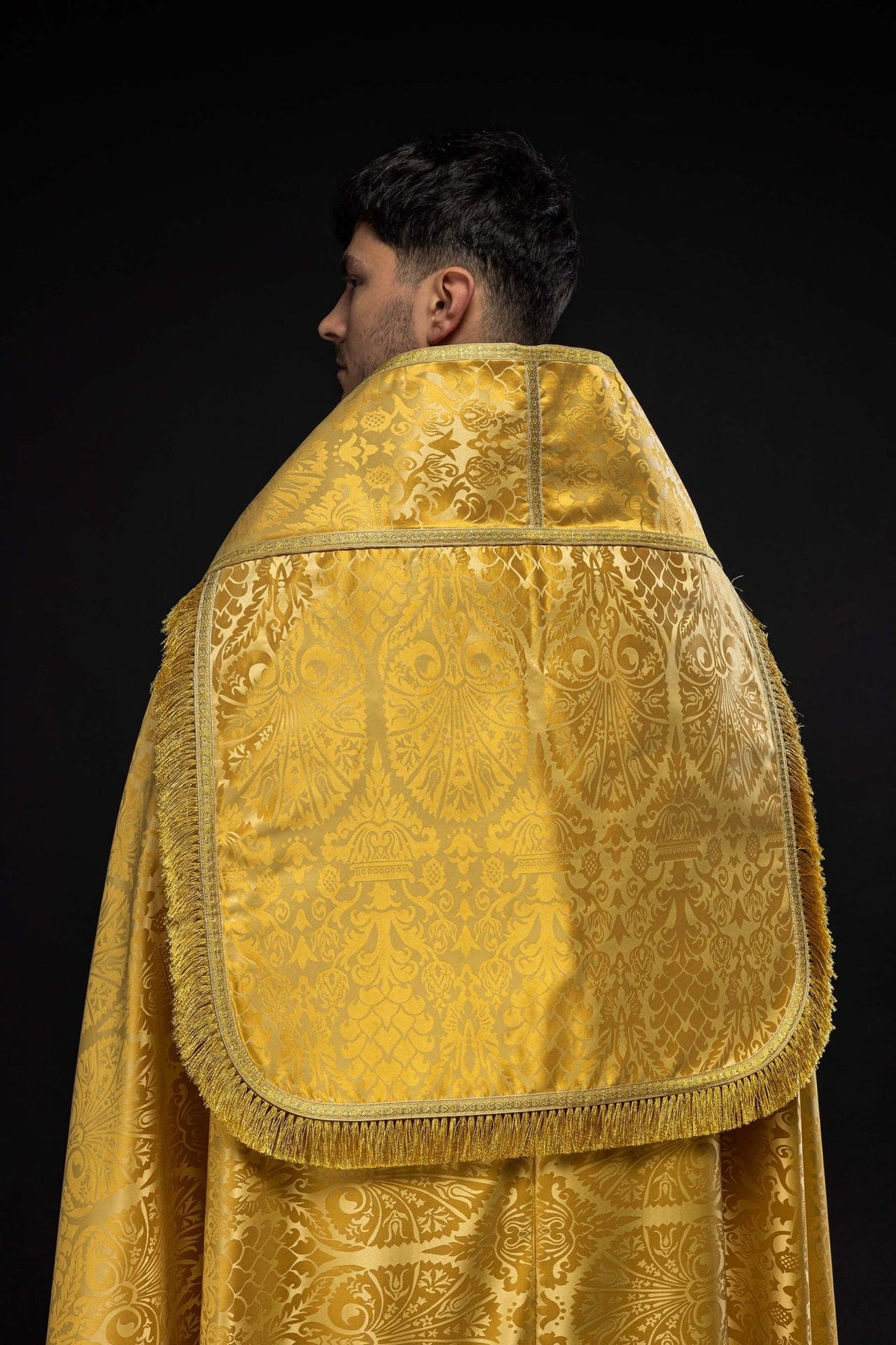 Gold cope back view with floral jacquard fabric, bordered shoulder panel and gold fringe