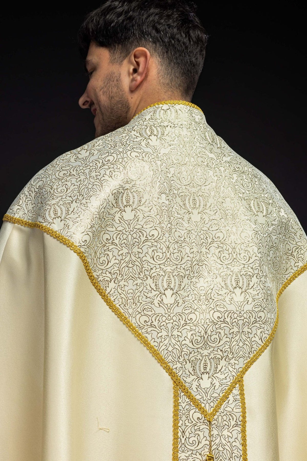 Embroidered ecru stole close-up with gold cross and scalloped edging