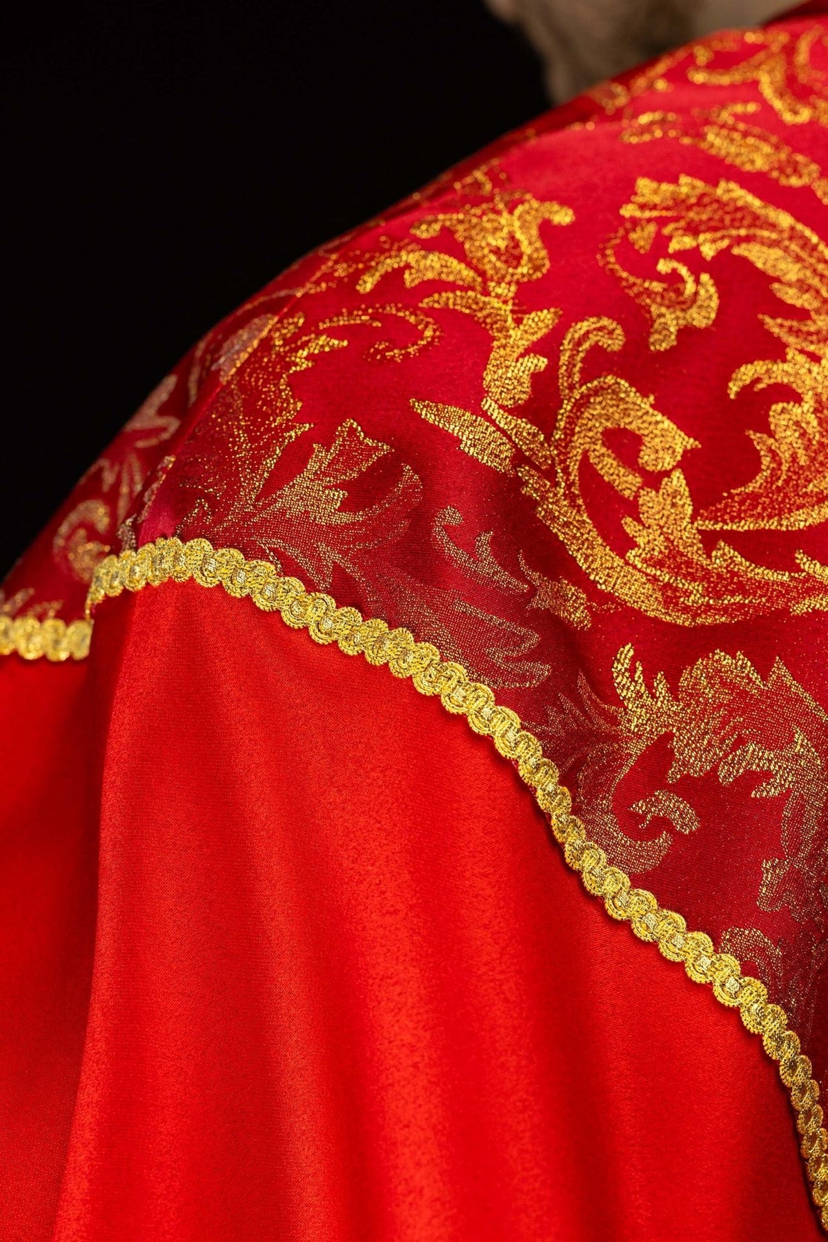 Red cope, back view with gold floral jacquard fabric and tassel