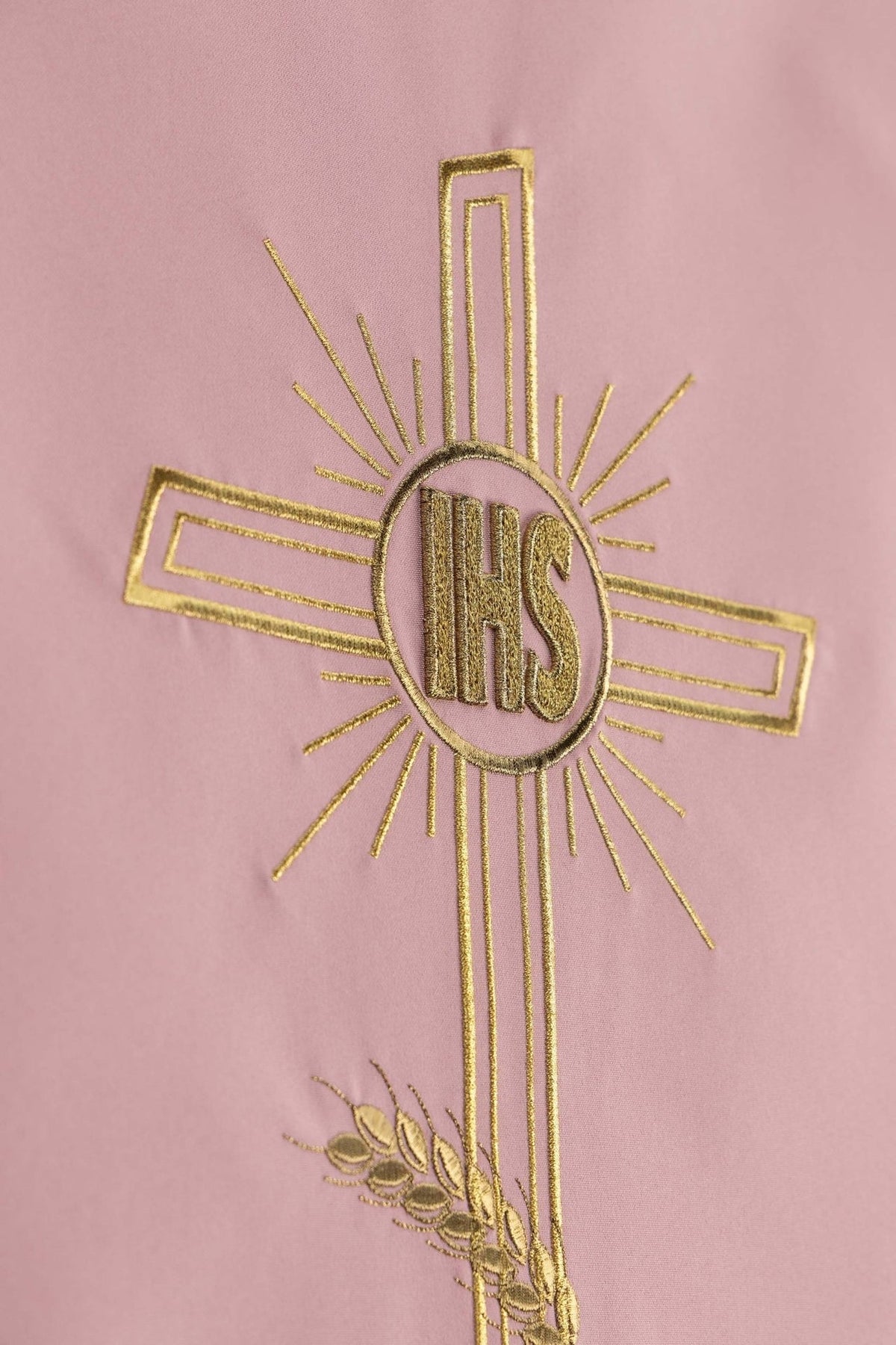 Church lectern cover close-up showing gold embroidered cross and IHS monogram