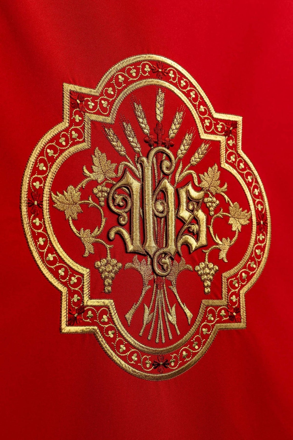 Church lectern cover close-up showing gold JHS embroidery on red fabric