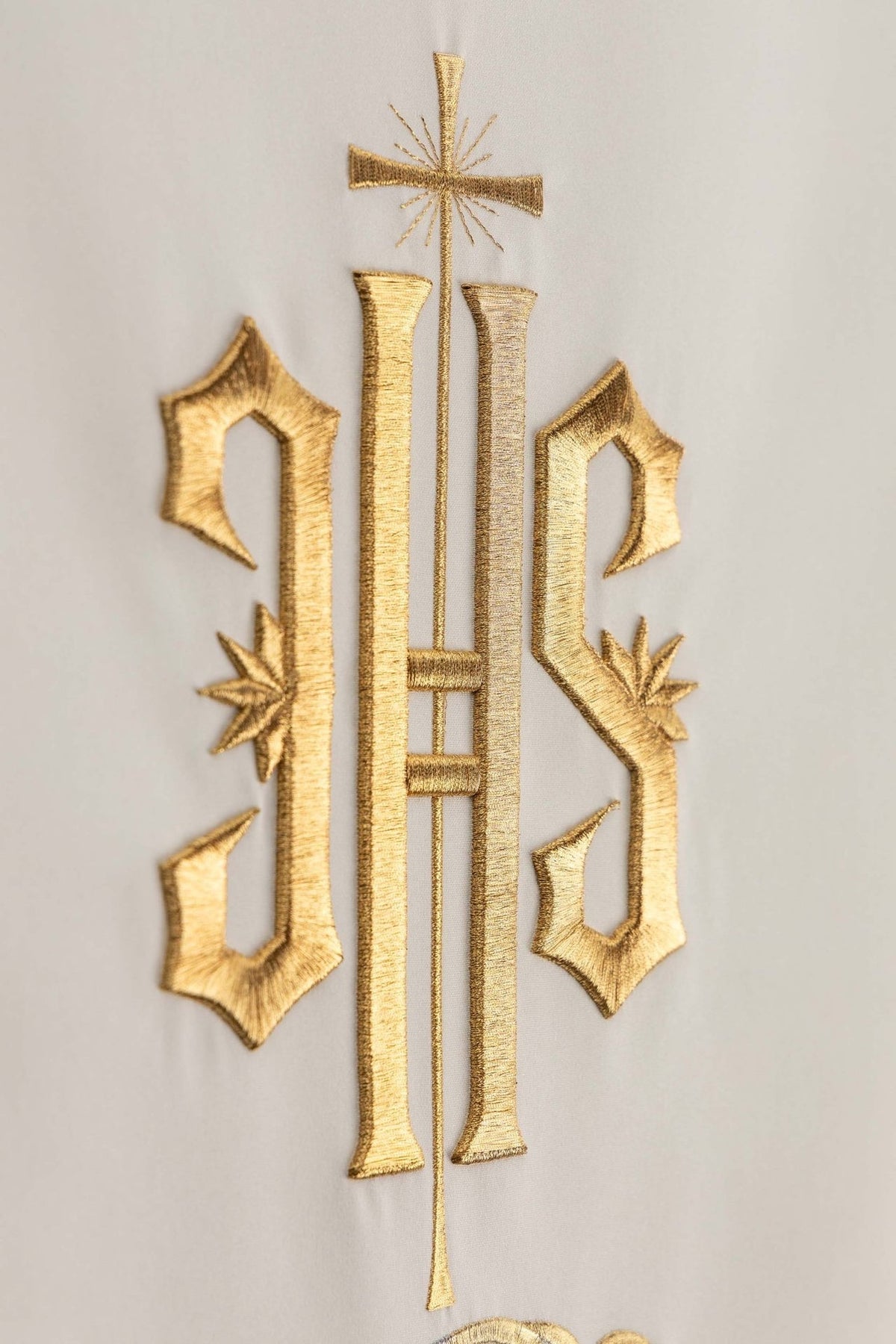 Church lectern cover close-up of gold embroidered IHS monogram and cross