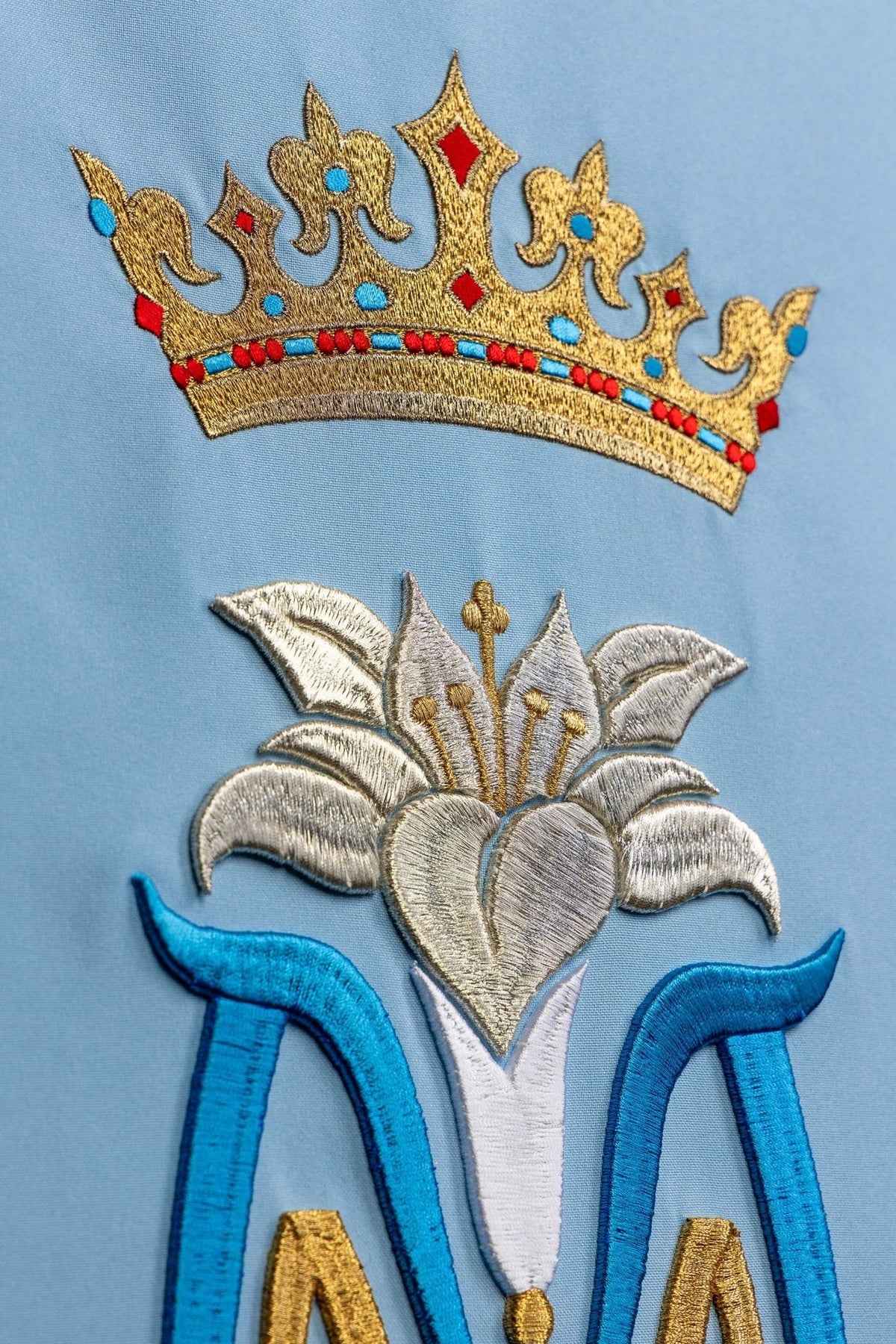 Church lectern cover close-up showing gold crown and embroidered Marian motif