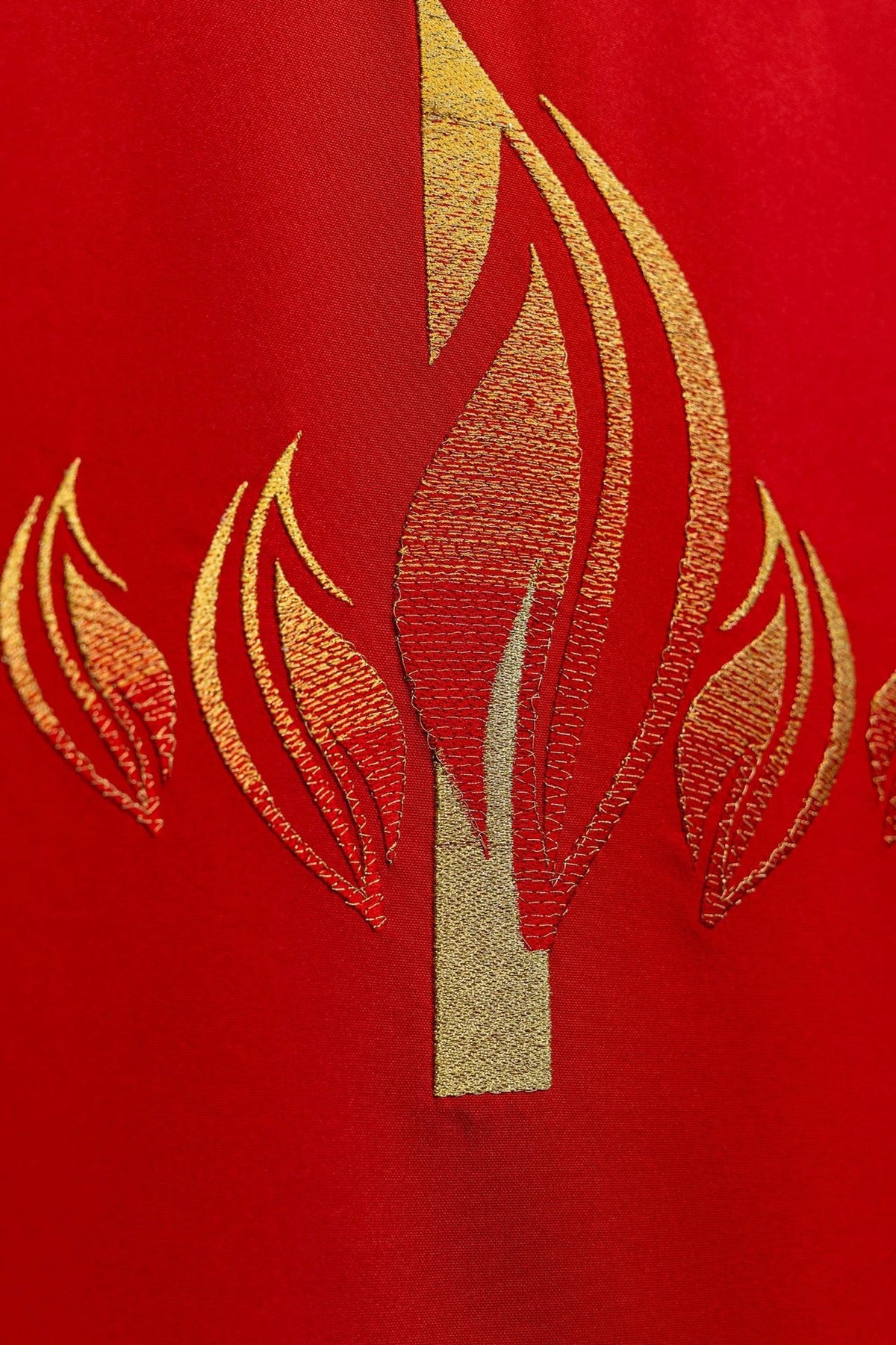 Red lectern cover detail showing gold embroidery of flames beneath the Holy Spirit dove