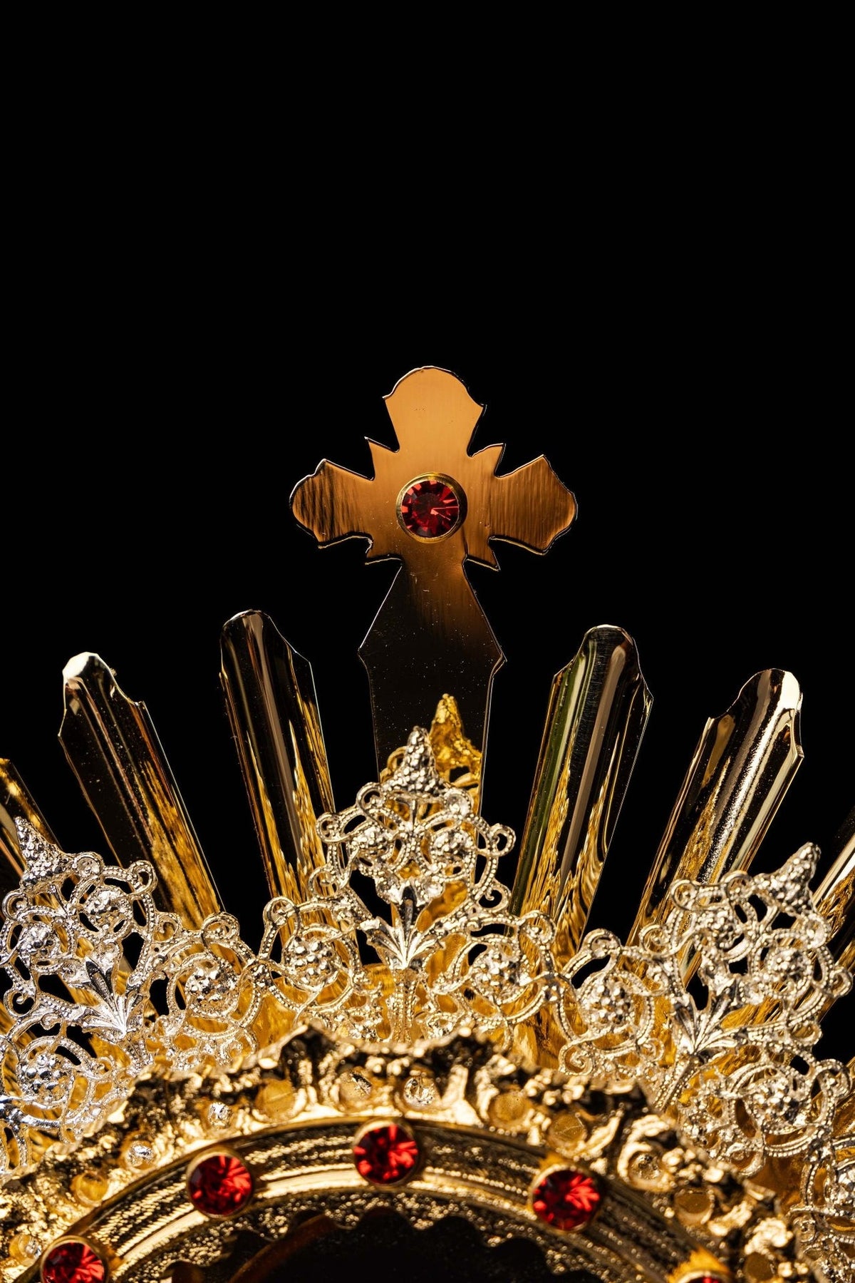 Monstrance close-up showing ornate filigree rays and red gemstones