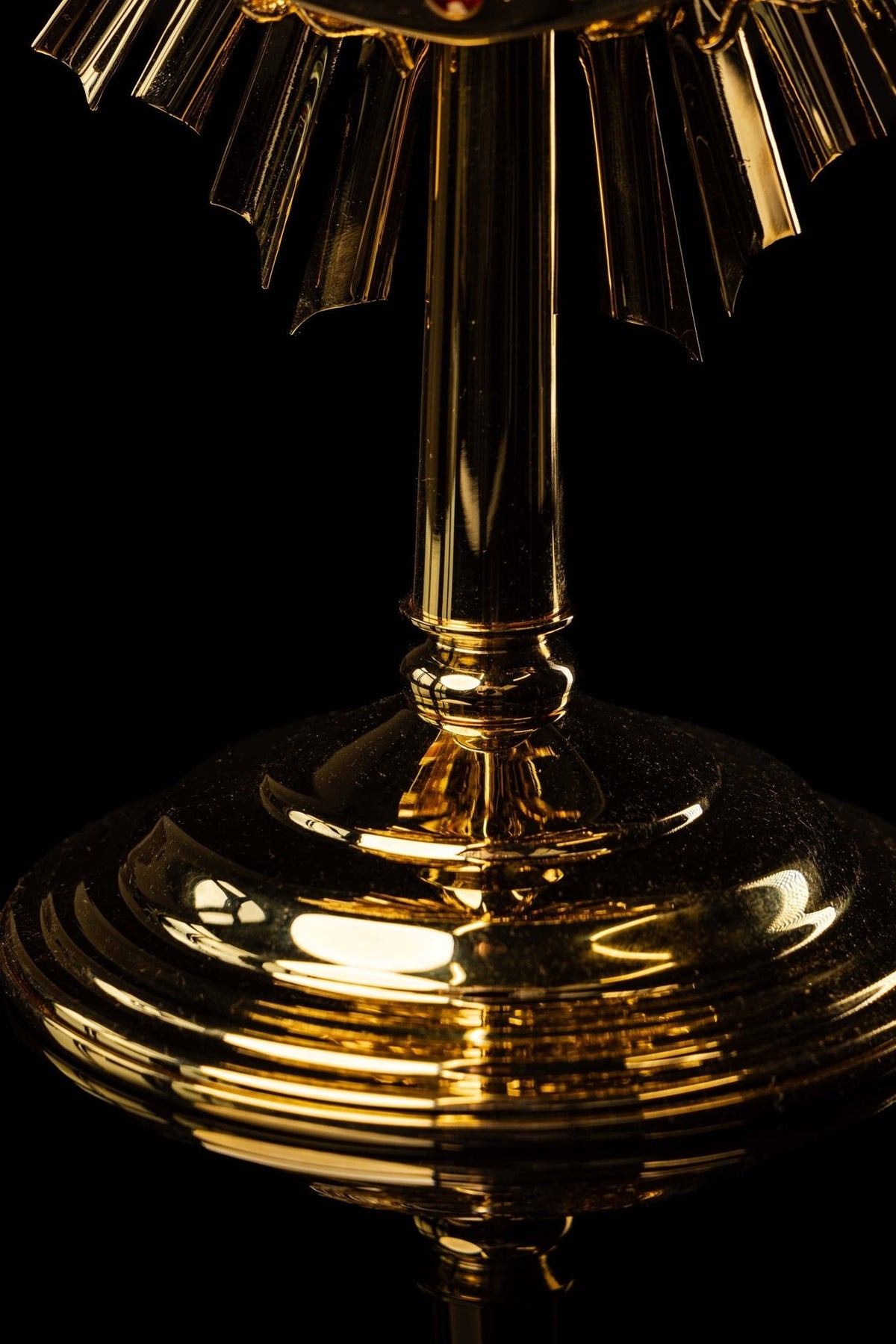 Catholic monstrance close-up of gold stem and tiered circular base