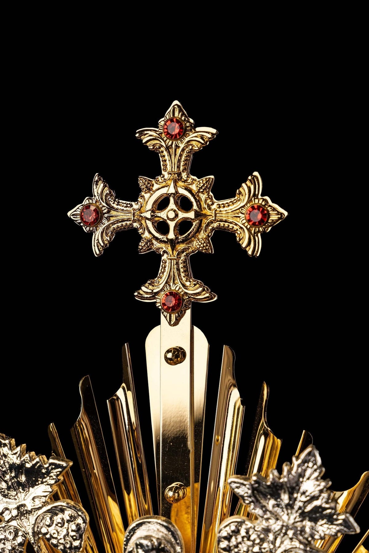 Monstrance close-up of silver-tone grape clusters and pointed gold rays