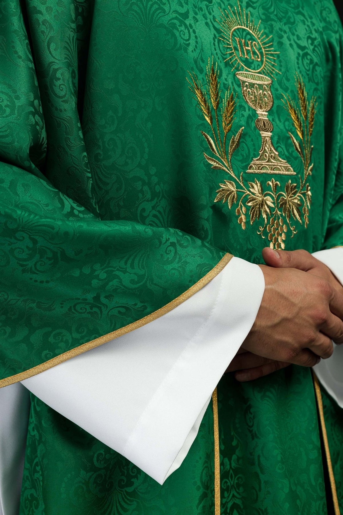 Green chasuble detail showing gold chalice embroidery and jacquard fabric