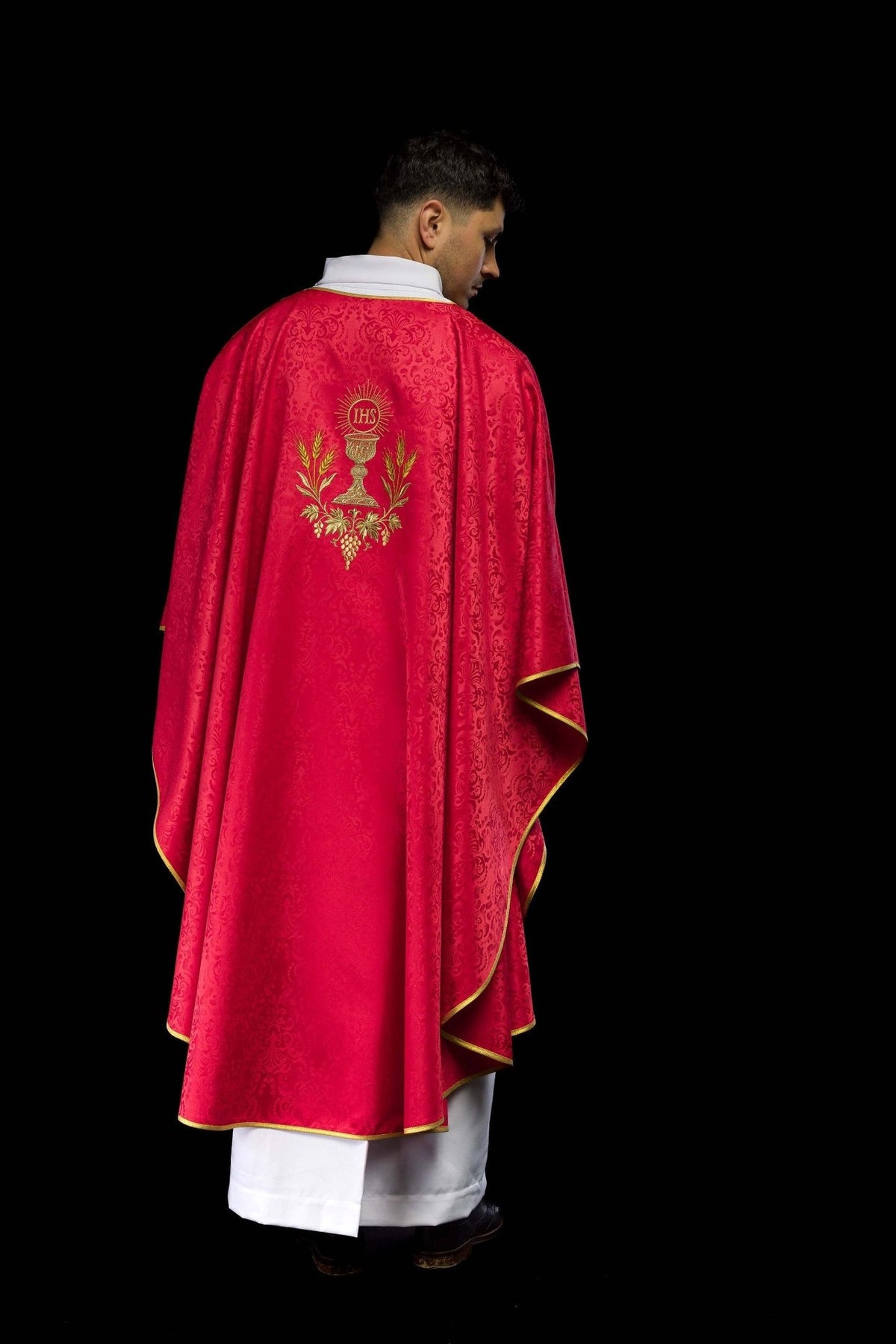 Red chasuble, back worn view with gold-trimmed edges and embroidery