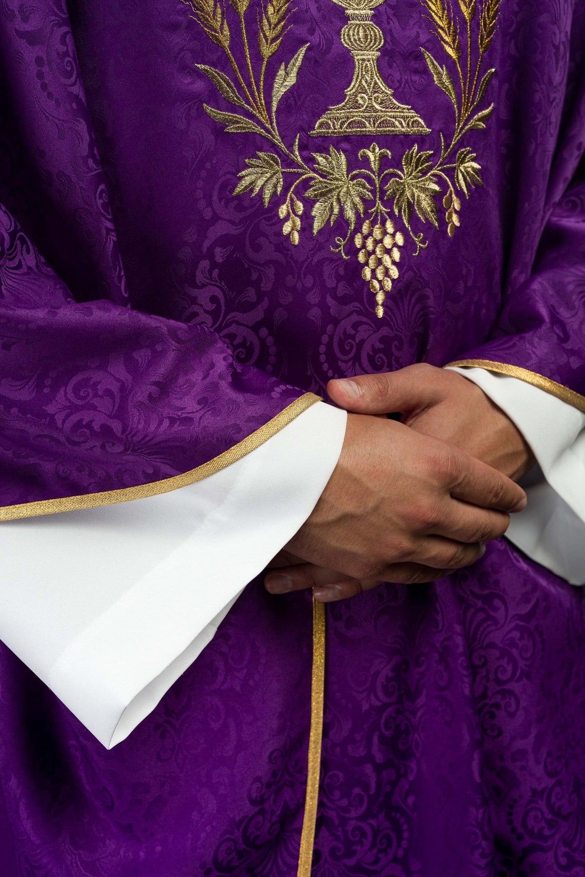 Purple chasuble close-up showing gold chalice, vine and wheat embroidery