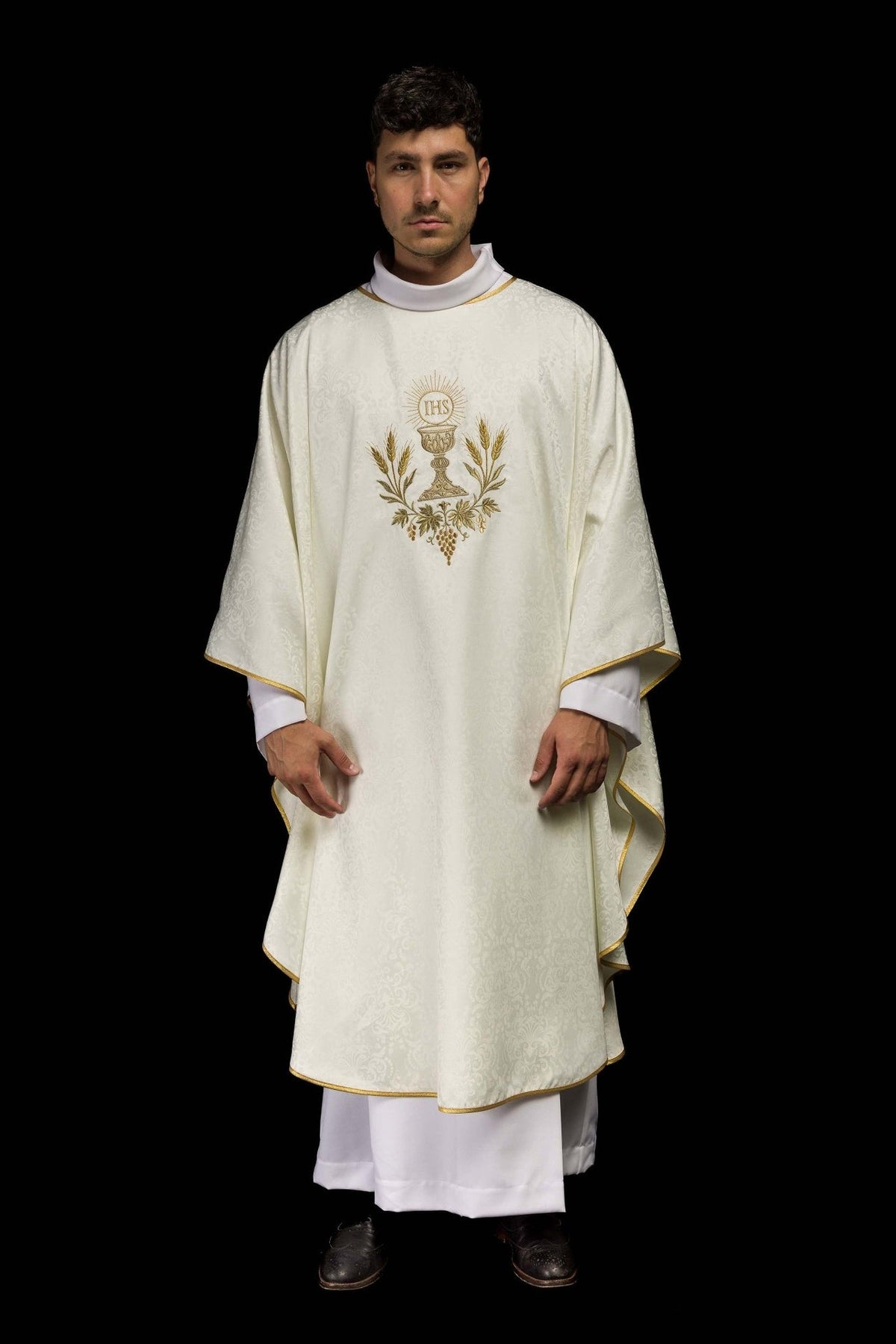 Ecru liturgical chasuble worn front view with gold trim and Eucharistic embroidery