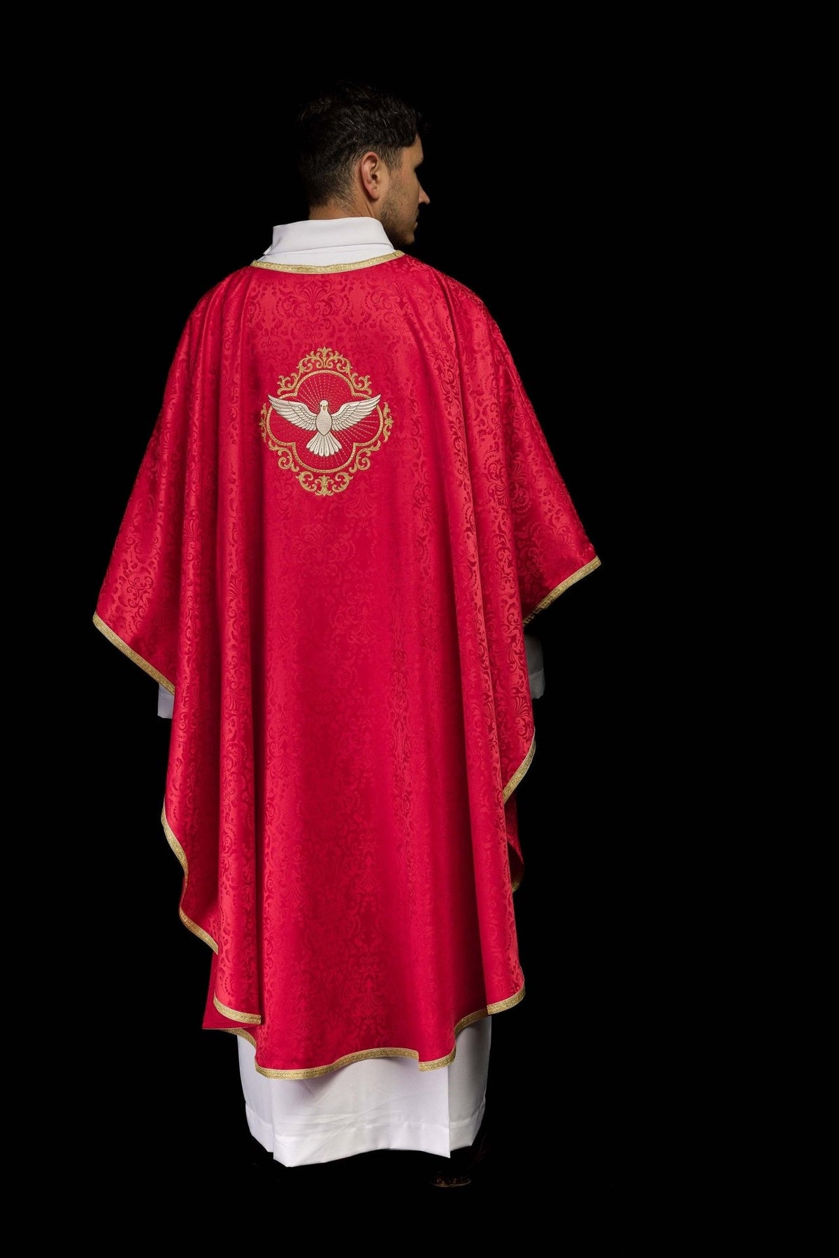 Red chasuble worn back view with jacquard fabric and gold trim