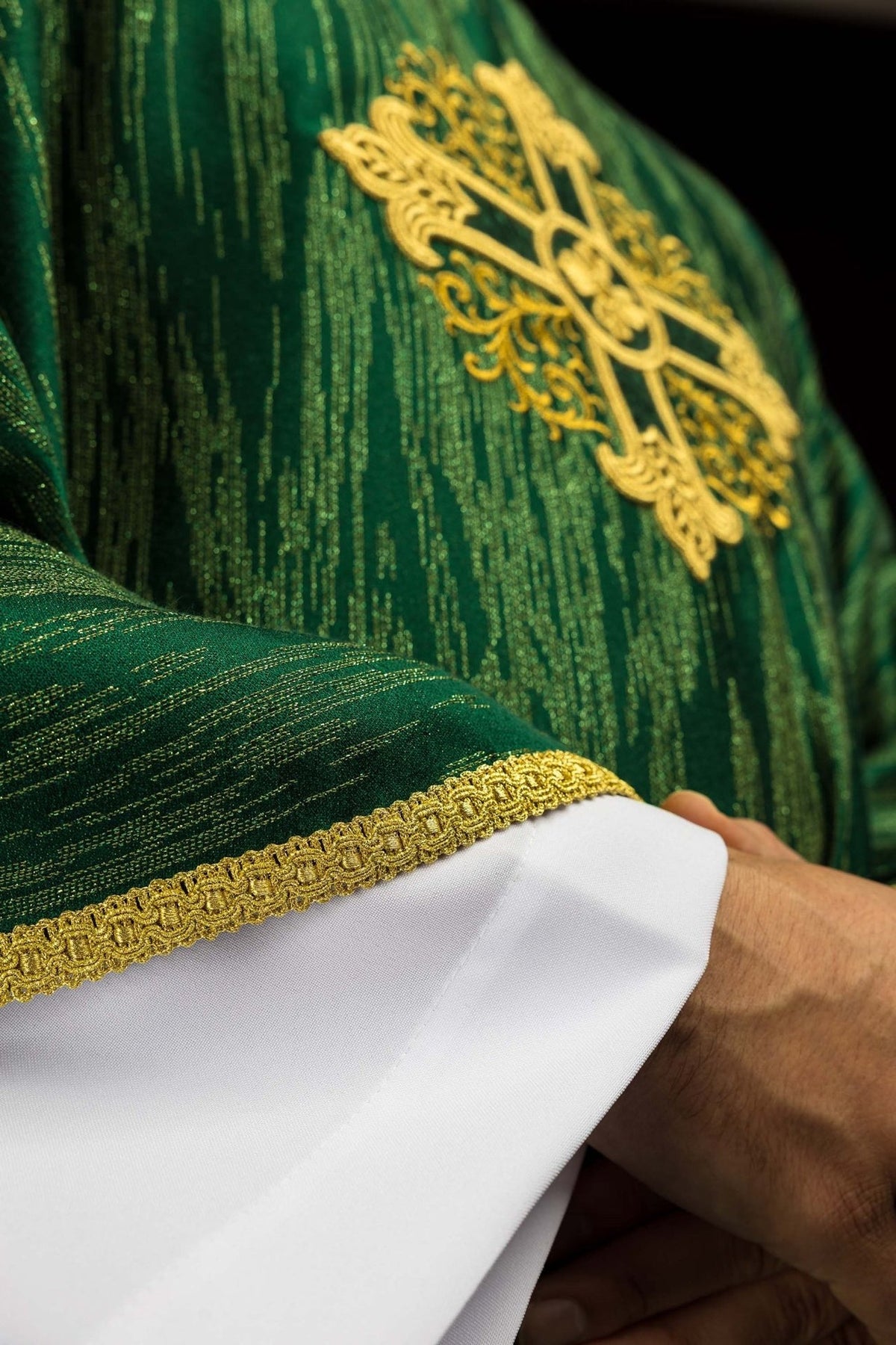 Green chasuble close-up of gold cross embroidery and sleeve trim