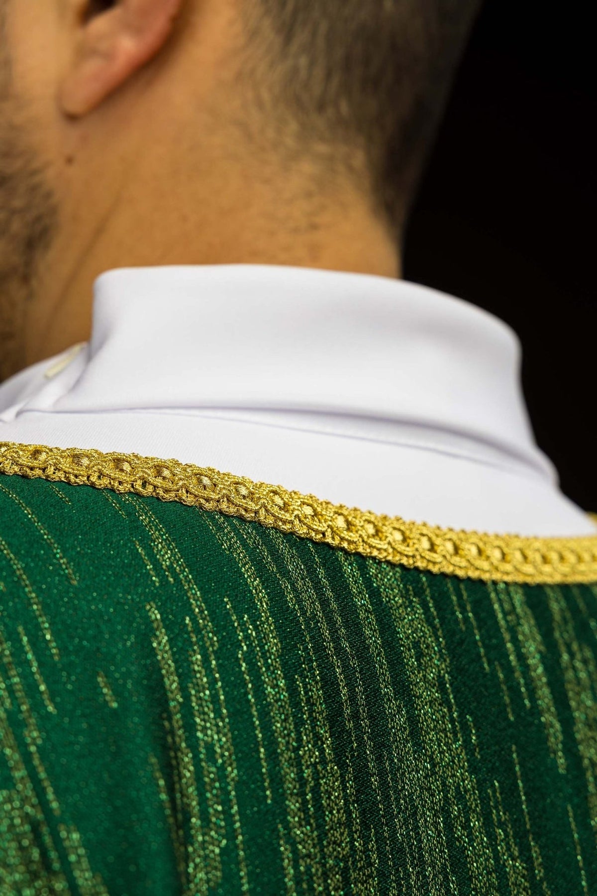 Green chasuble close-up of decorative fabric and gold neckline trim