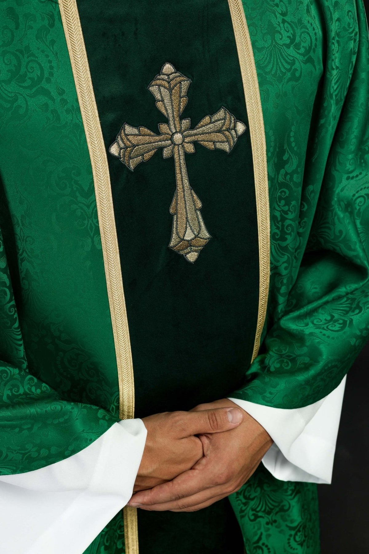 Green chasuble front detail showing cross embroidery and gold trim