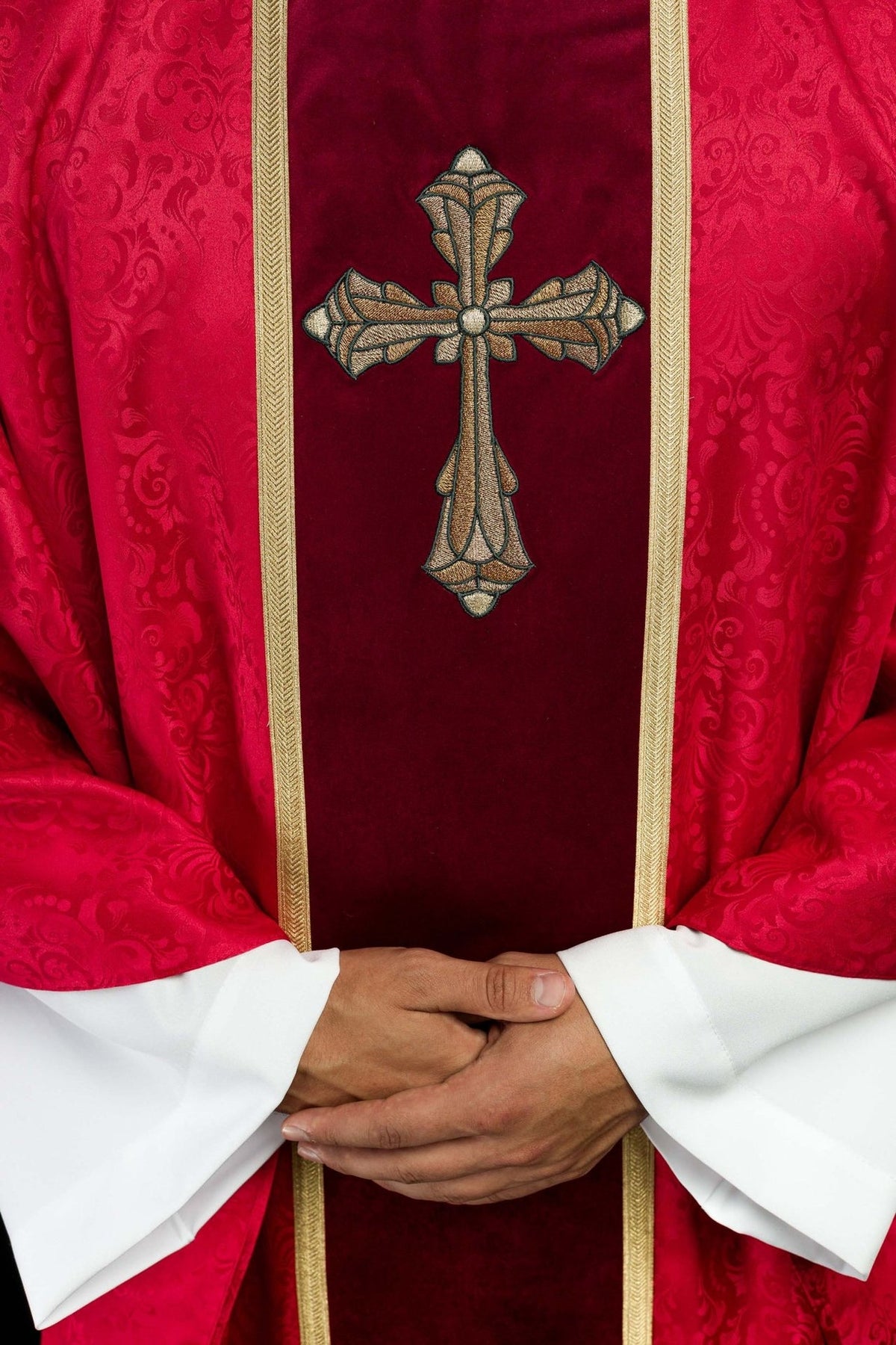 Red chasuble close-up of gold cross embroidery and trim