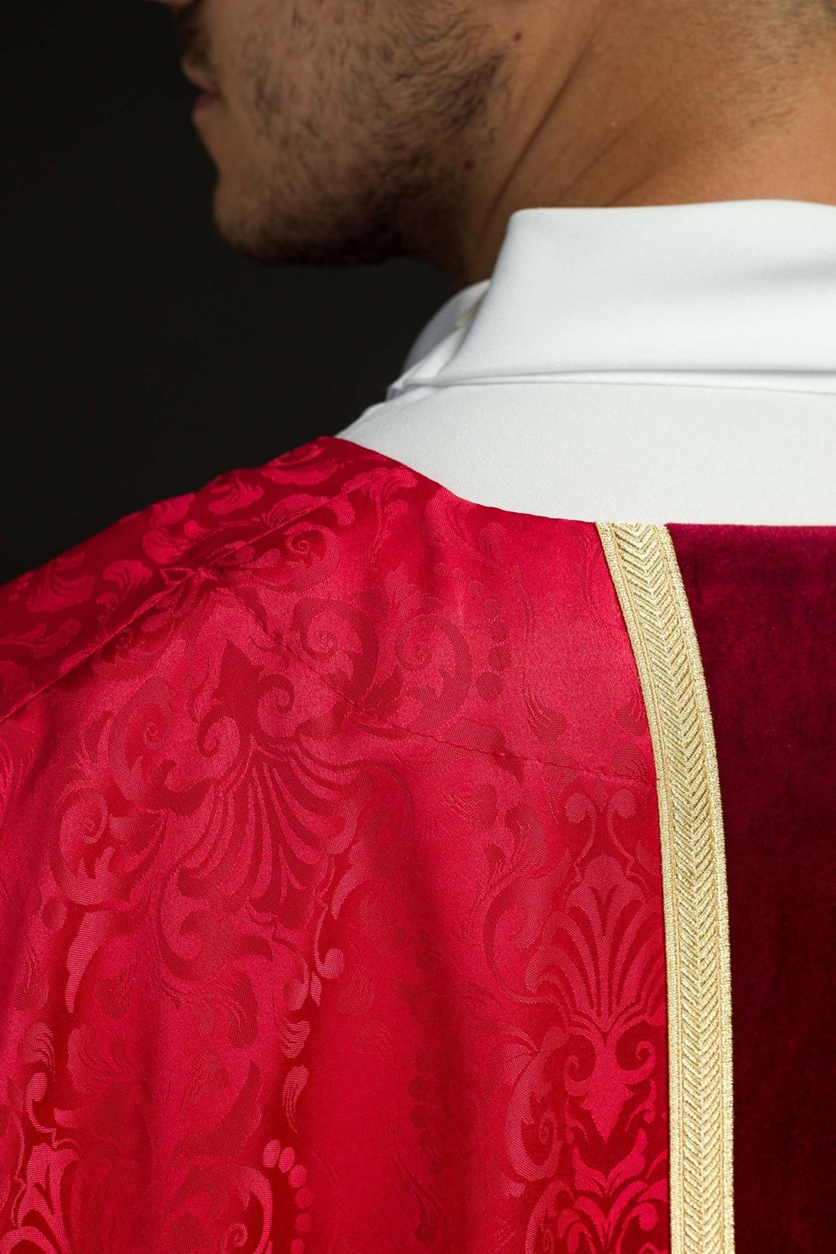 Red chasuble side close-up with jacquard fabric and gold trim