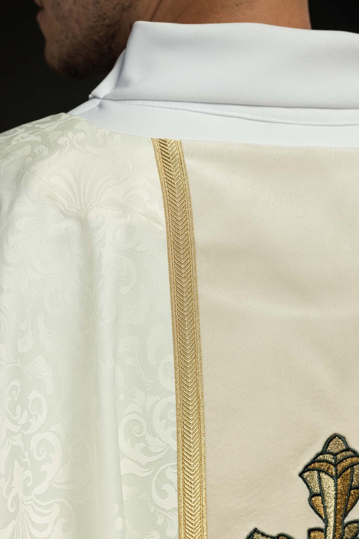 Ecru chasuble close-up of gold trim beside the jacquard fabric