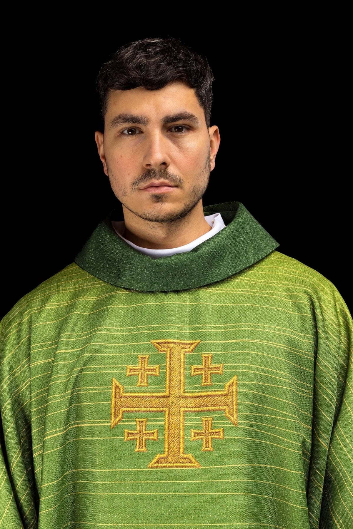 Green chasuble close-up showing collar, gold trim and Jerusalem cross