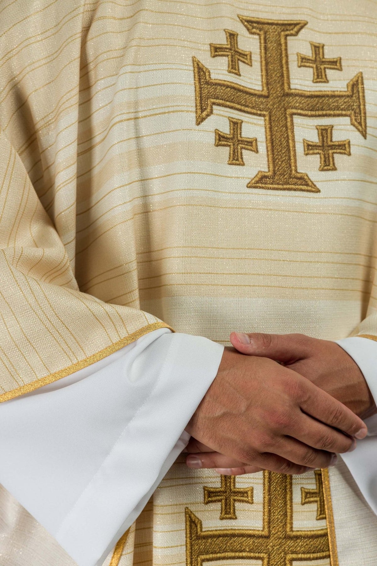 Ecru chasuble detail showing gold Jerusalem cross, striped fabric and trim
