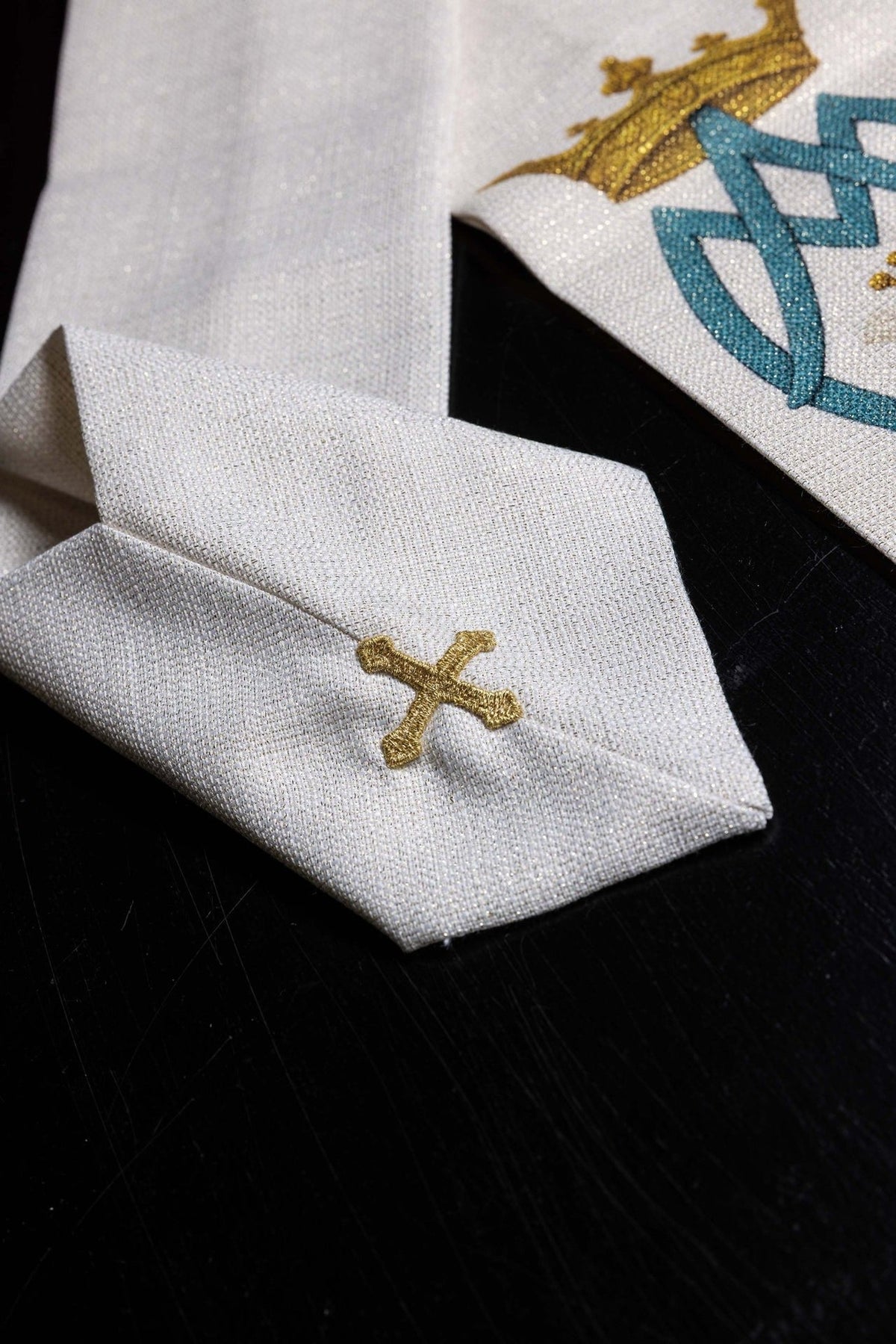 Marian chasuble detail showing white fabric and gold embroidered cross