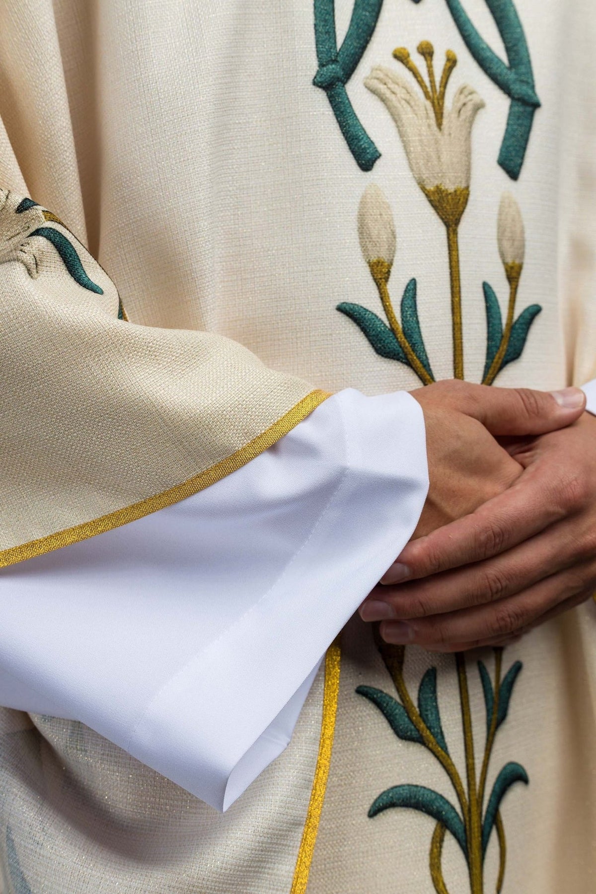 Marian chasuble close-up showing cream fabric, gold trim and printed lily pattern
