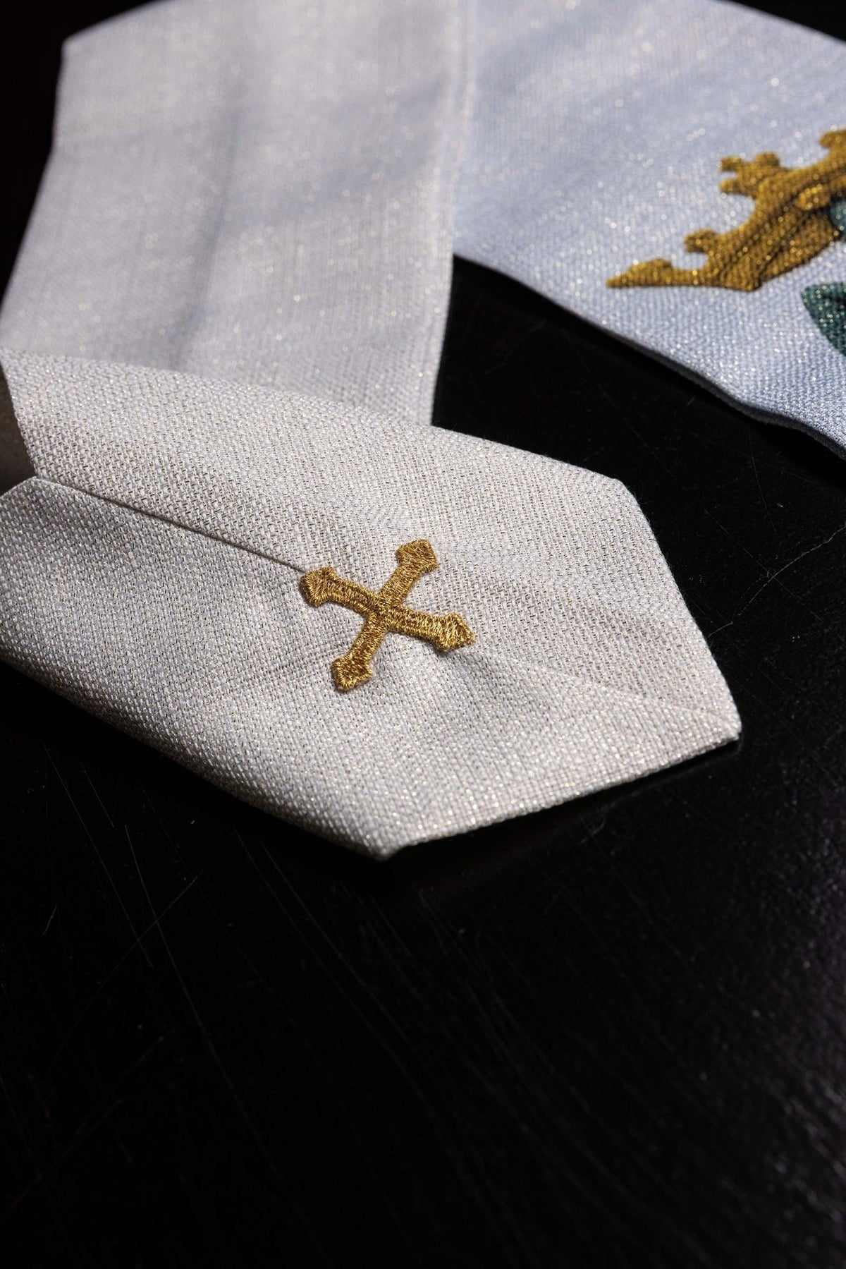Light blue and ecru Marian chasuble trim close-up with gold embroidered cross