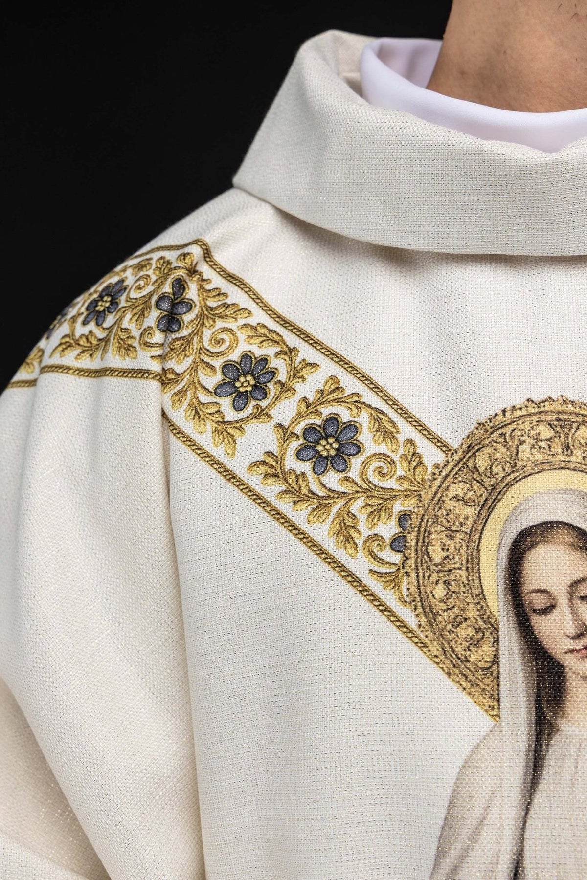 Marian chasuble side detail showing cream fabric, floral trim and gold edging