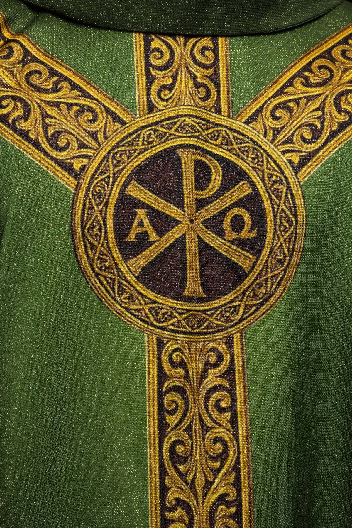 Green chasuble close-up showing the gold Pax cross and ornate orphrey