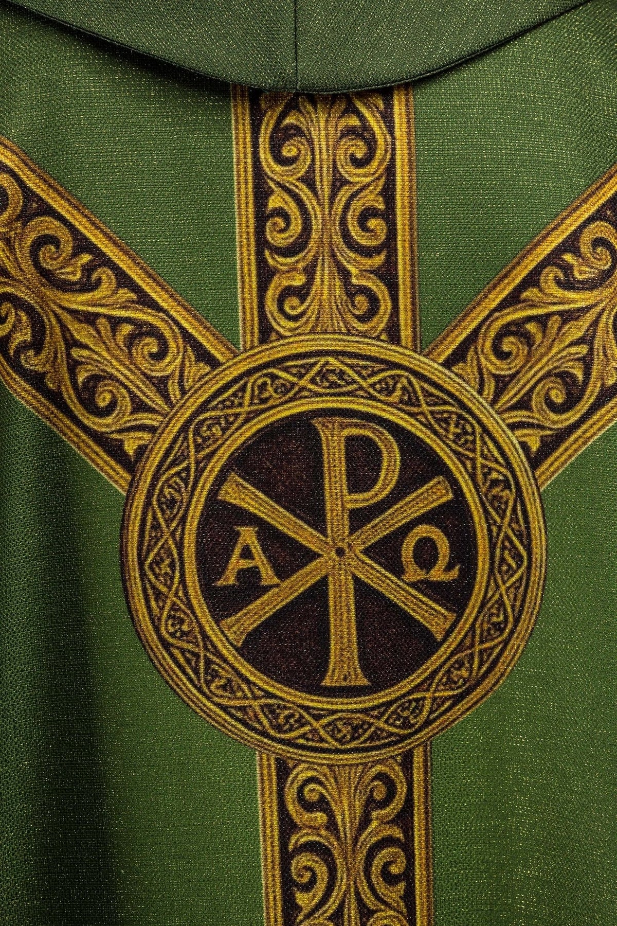 Green chasuble close-up showing gold scrollwork orphrey and Pax cross