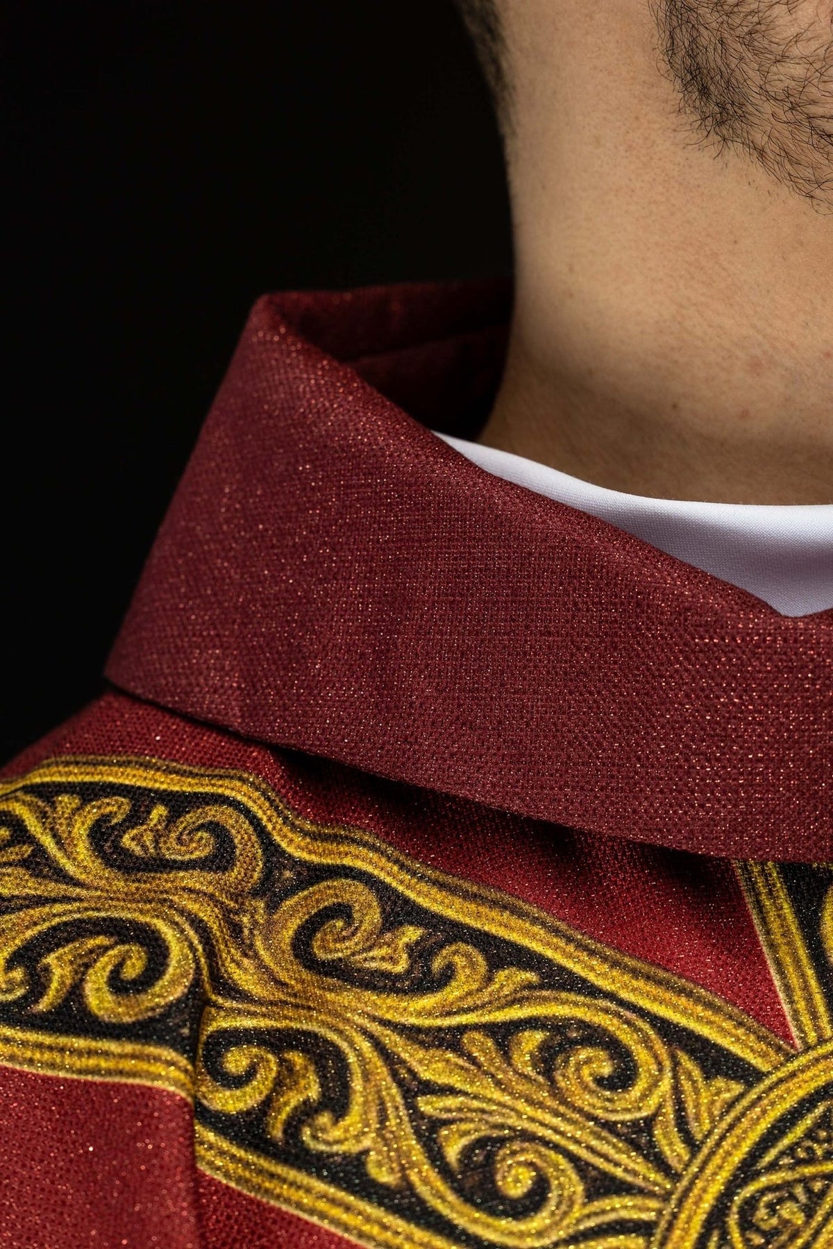 Red chasuble close-up of ornate gold vertical orphrey on red fabric