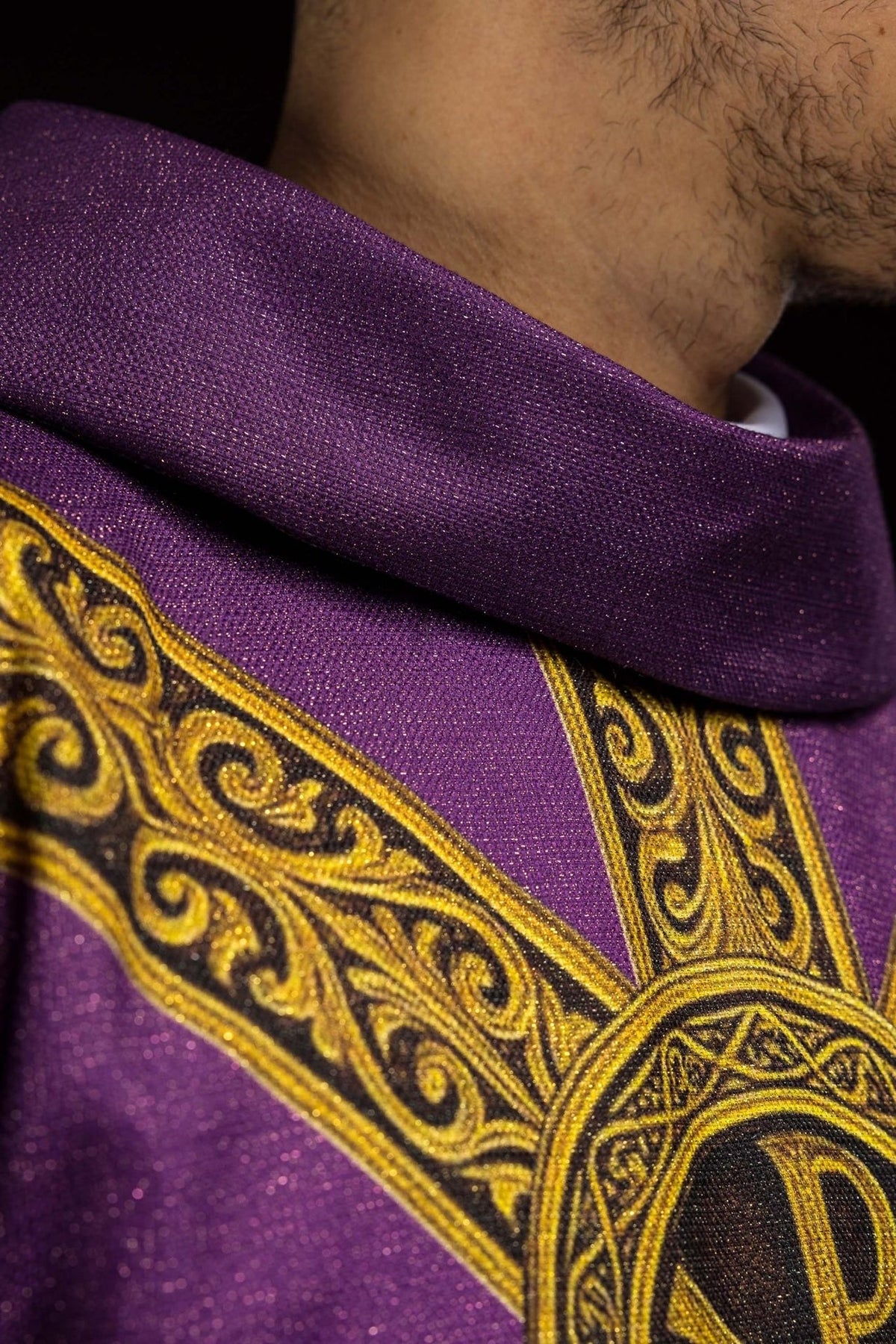 Pax chasuble close-up showing purple fabric, gold trim and ornate orphrey