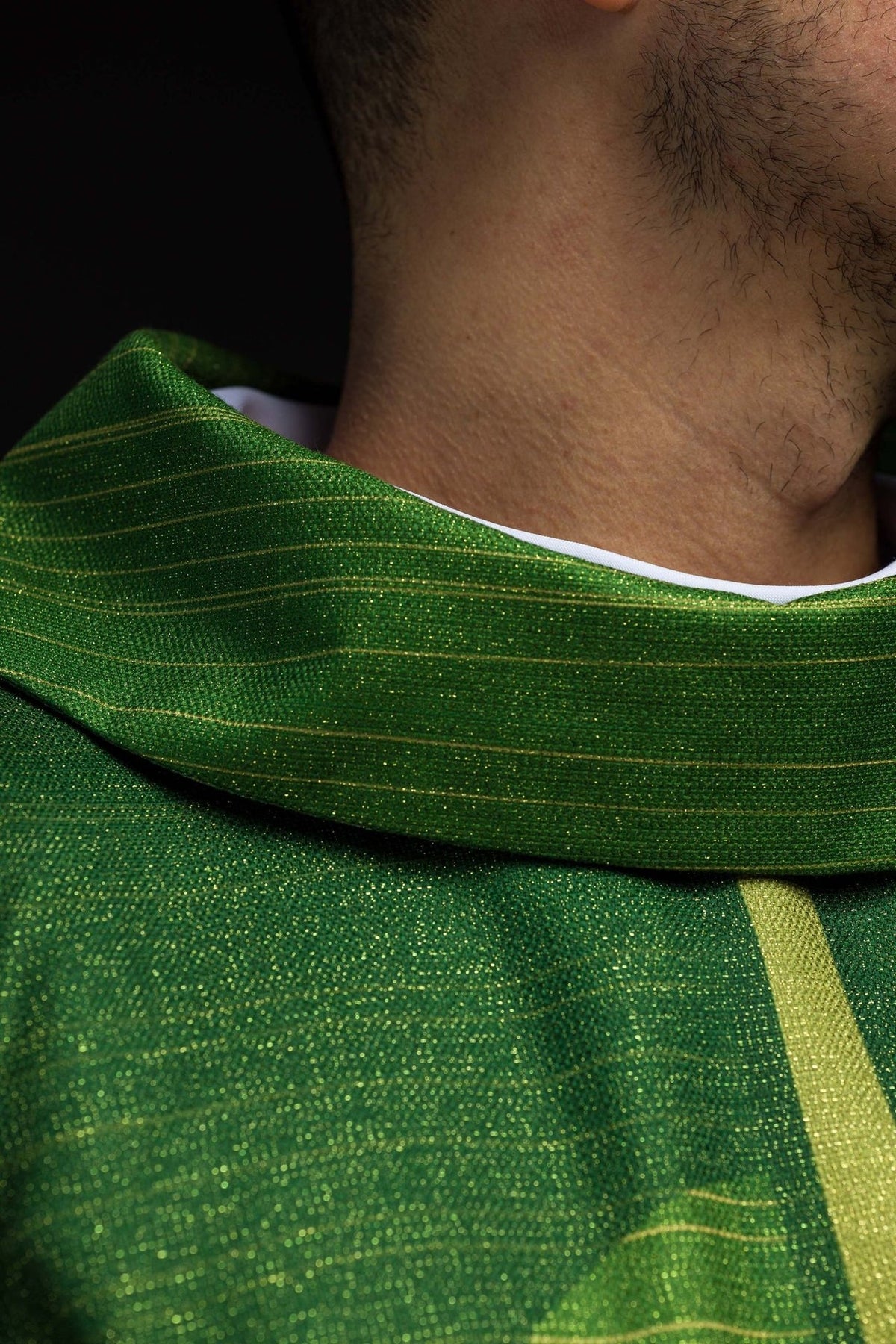 Green chasuble sleeve close-up with gold stripe and white lining