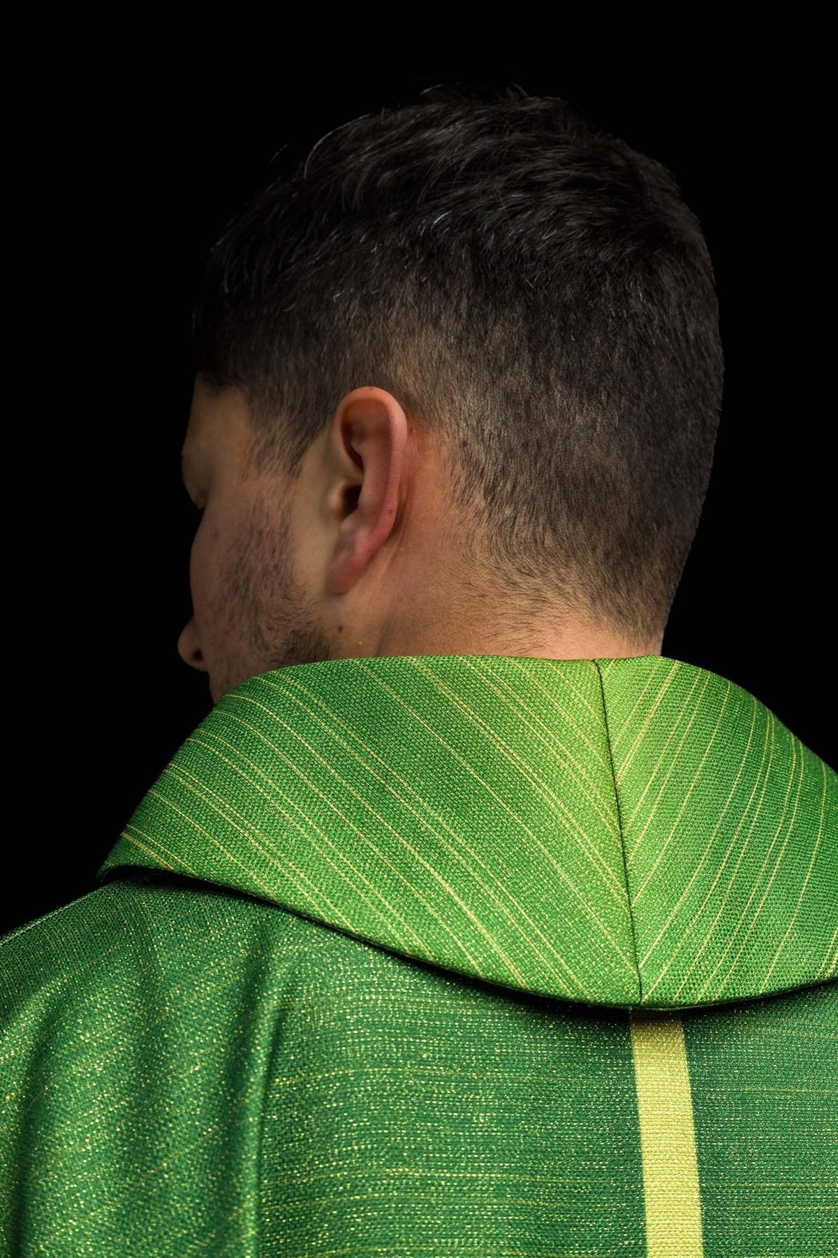 Green chasuble collar close-up with fine gold horizontal lines