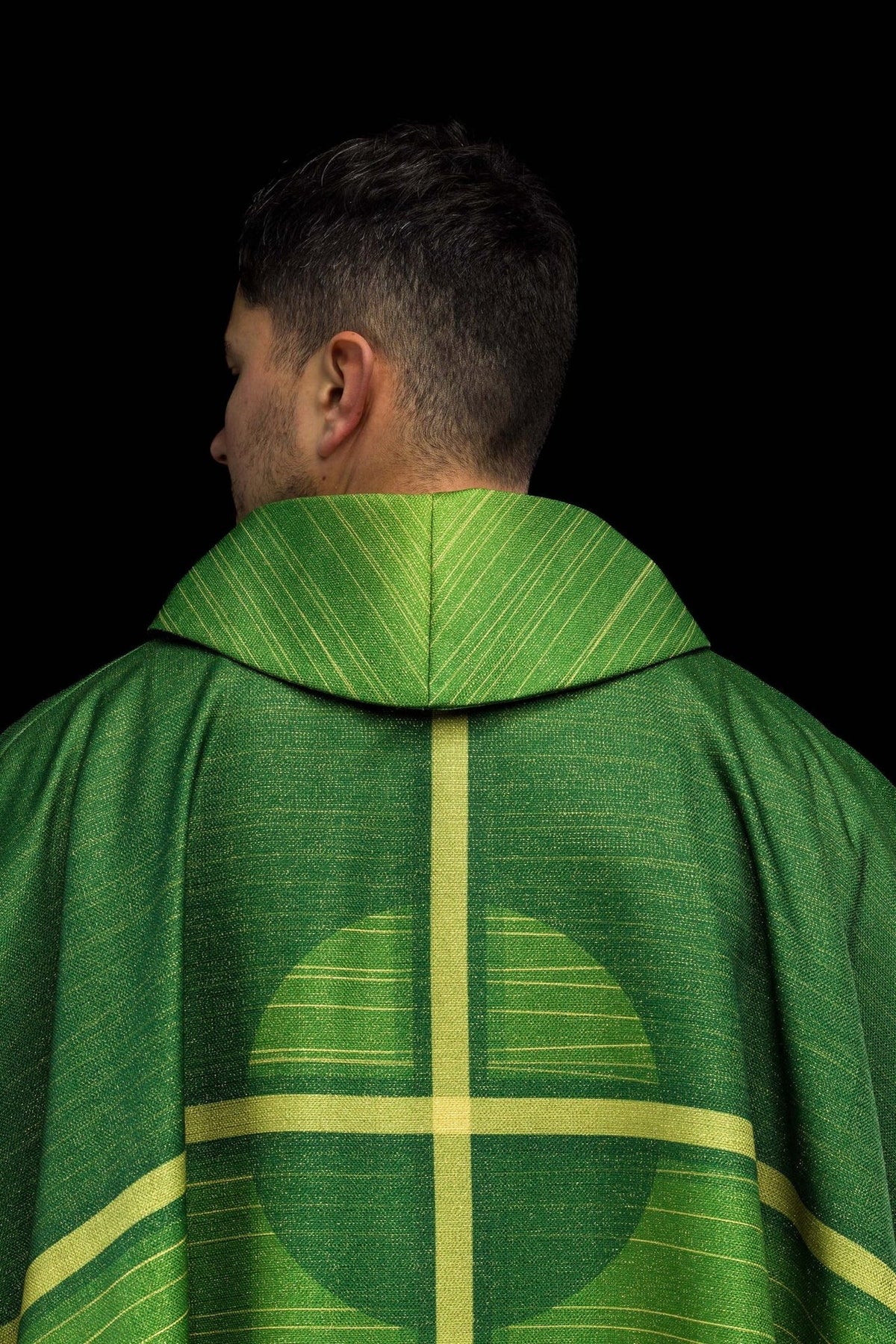 Green chasuble back close-up showing gold-striped collar and central cross