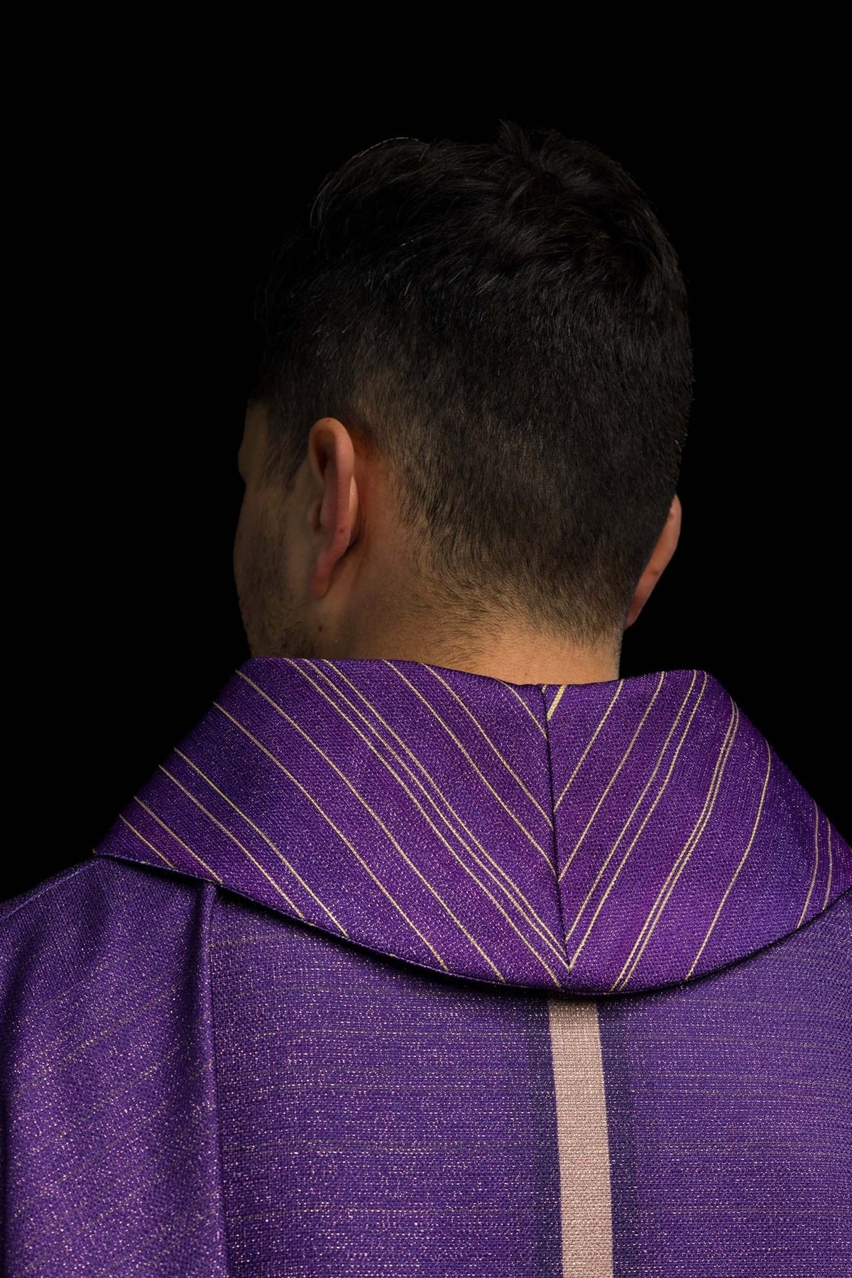 Purple cross chasuble, close-up side view showing striped sleeve and cross detail