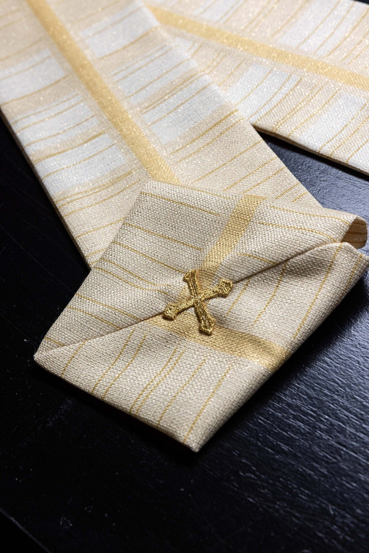 Ecru printed chasuble with close-up of gold cross motif and striped fabric