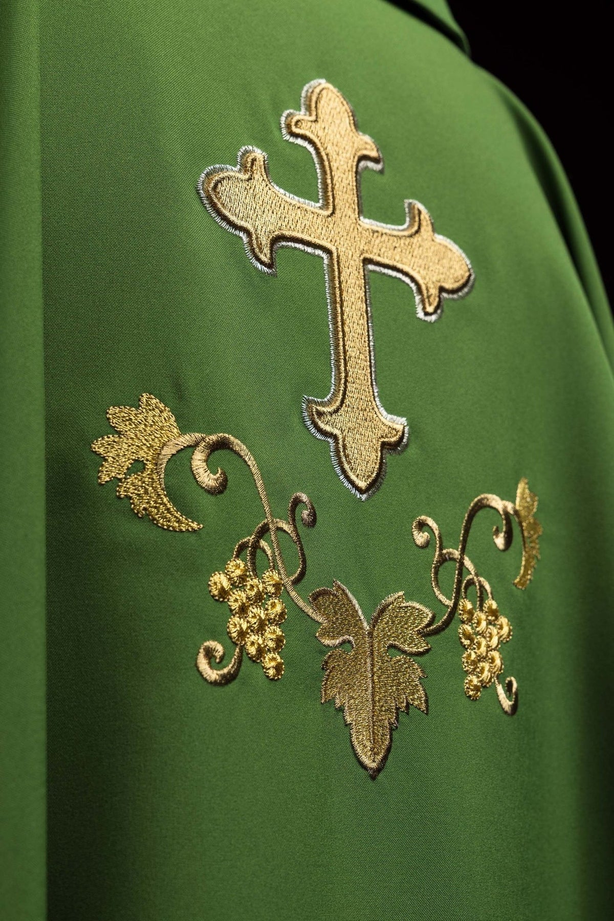 Green embroidered chasuble close-up with gold cross and floral embroidery