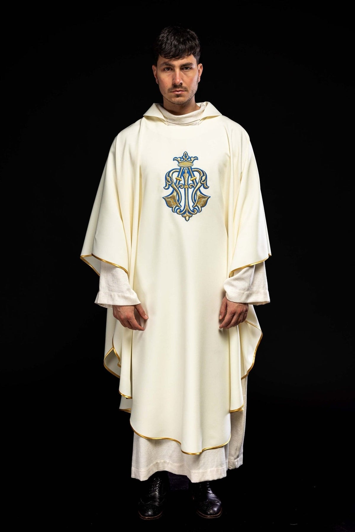 Ecru chasuble worn in full front view with Marian symbol and gold trim
