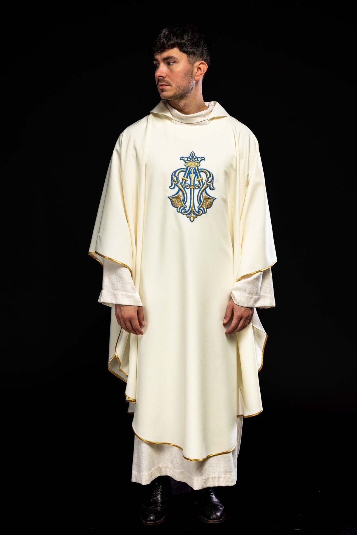 Ecru chasuble worn in front view with blue and gold Marian symbol