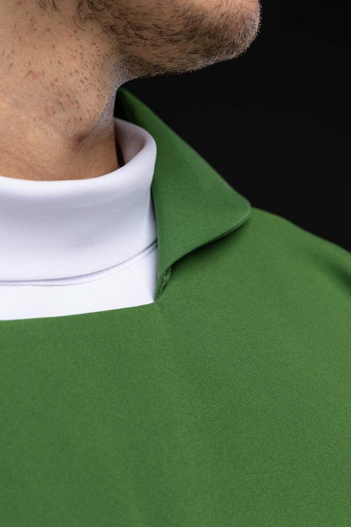 Green chasuble close-up showing wide collar and polyester fabric