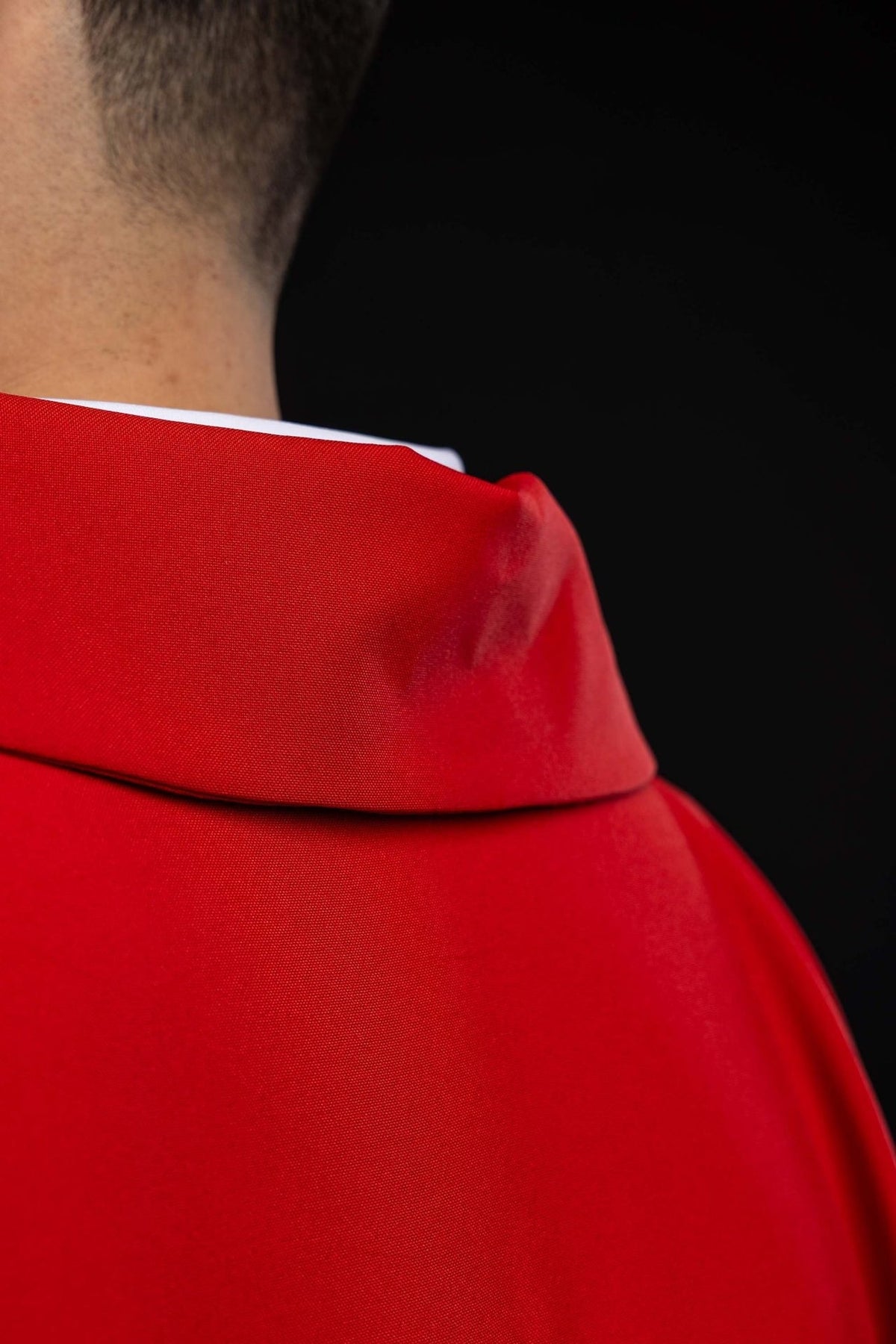 Red chasuble back view with embroidered gold cross and gold trim