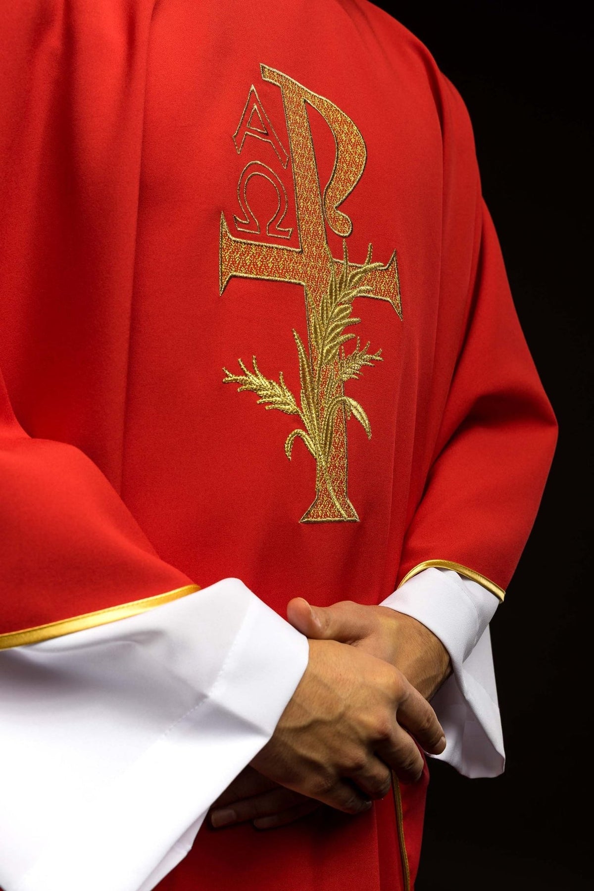 Red chasuble close-up showing gold cross and wheat embroidery