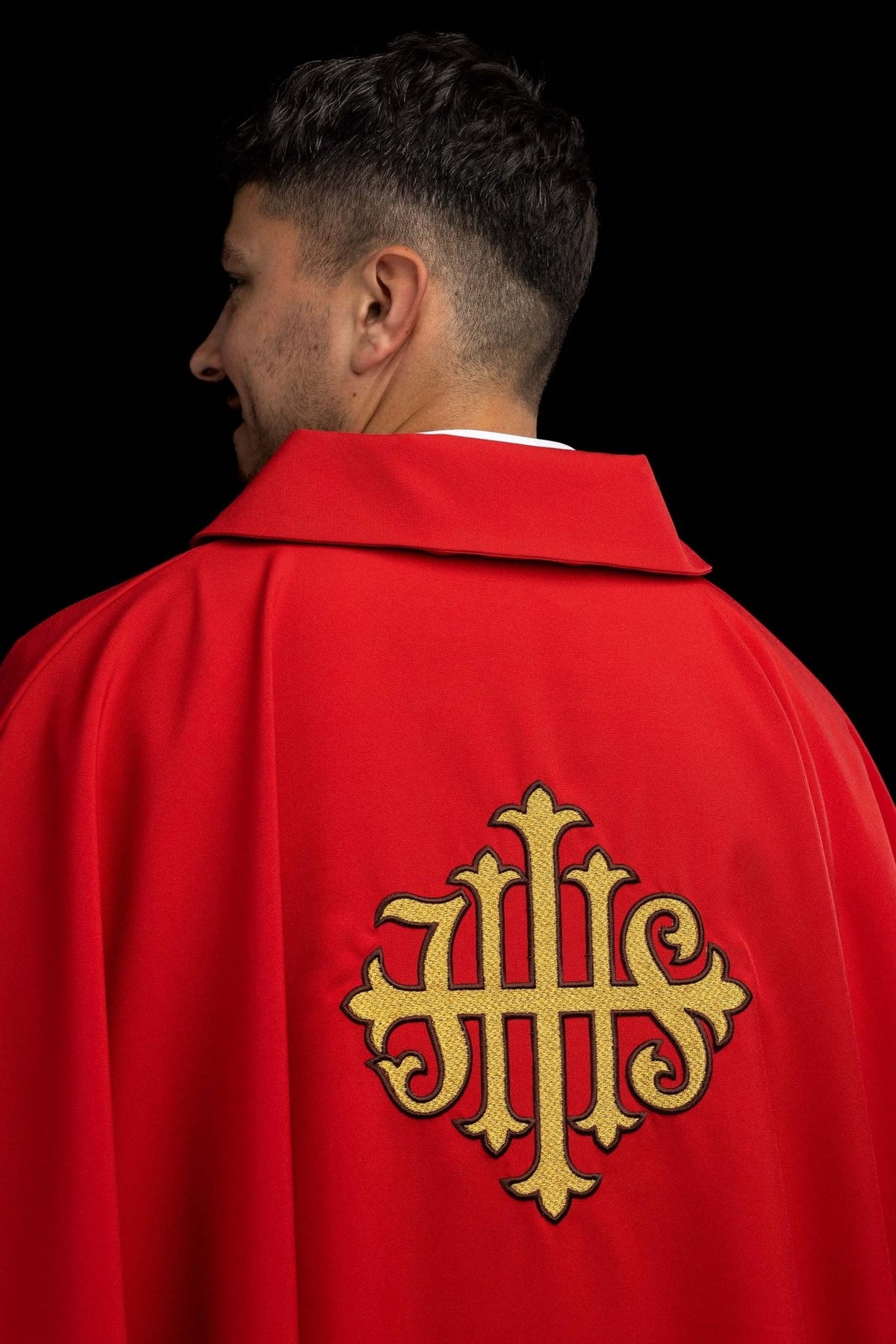 Red chasuble back view with gold embroidered JHS symbol and wide collar