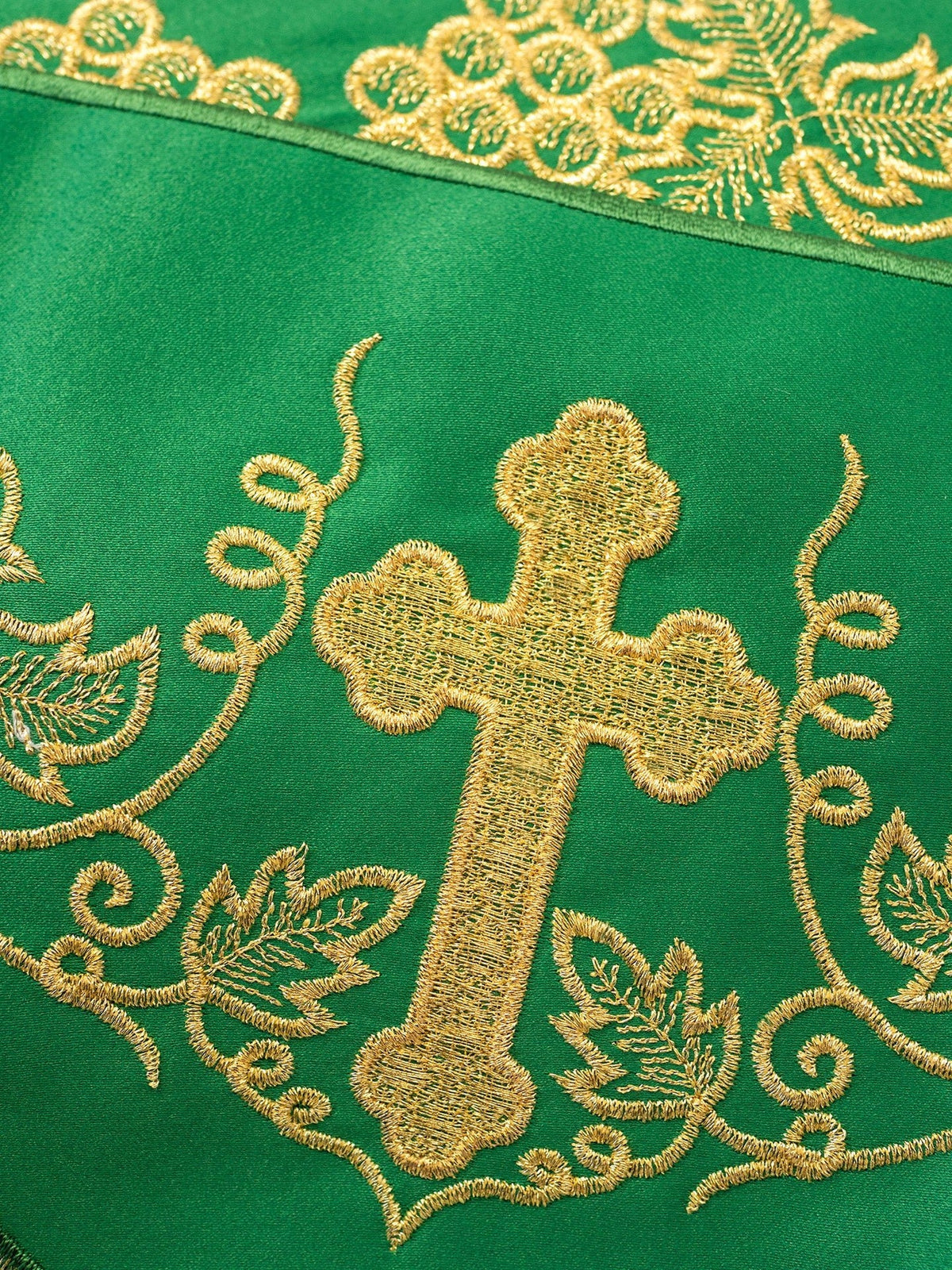 Green altar lace close-up showing gold cross and surrounding embroidery