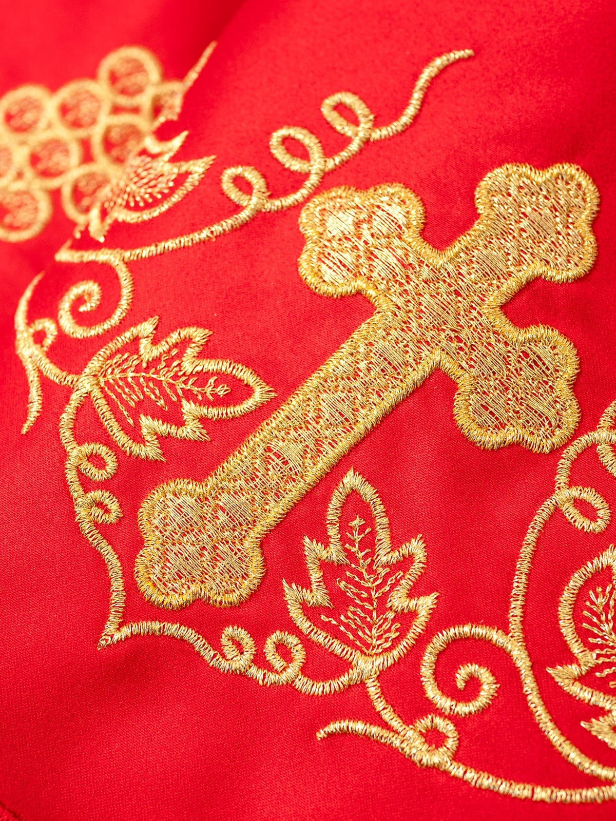Altar lace close-up showing gold cross, grapes and embroidery on red fabric