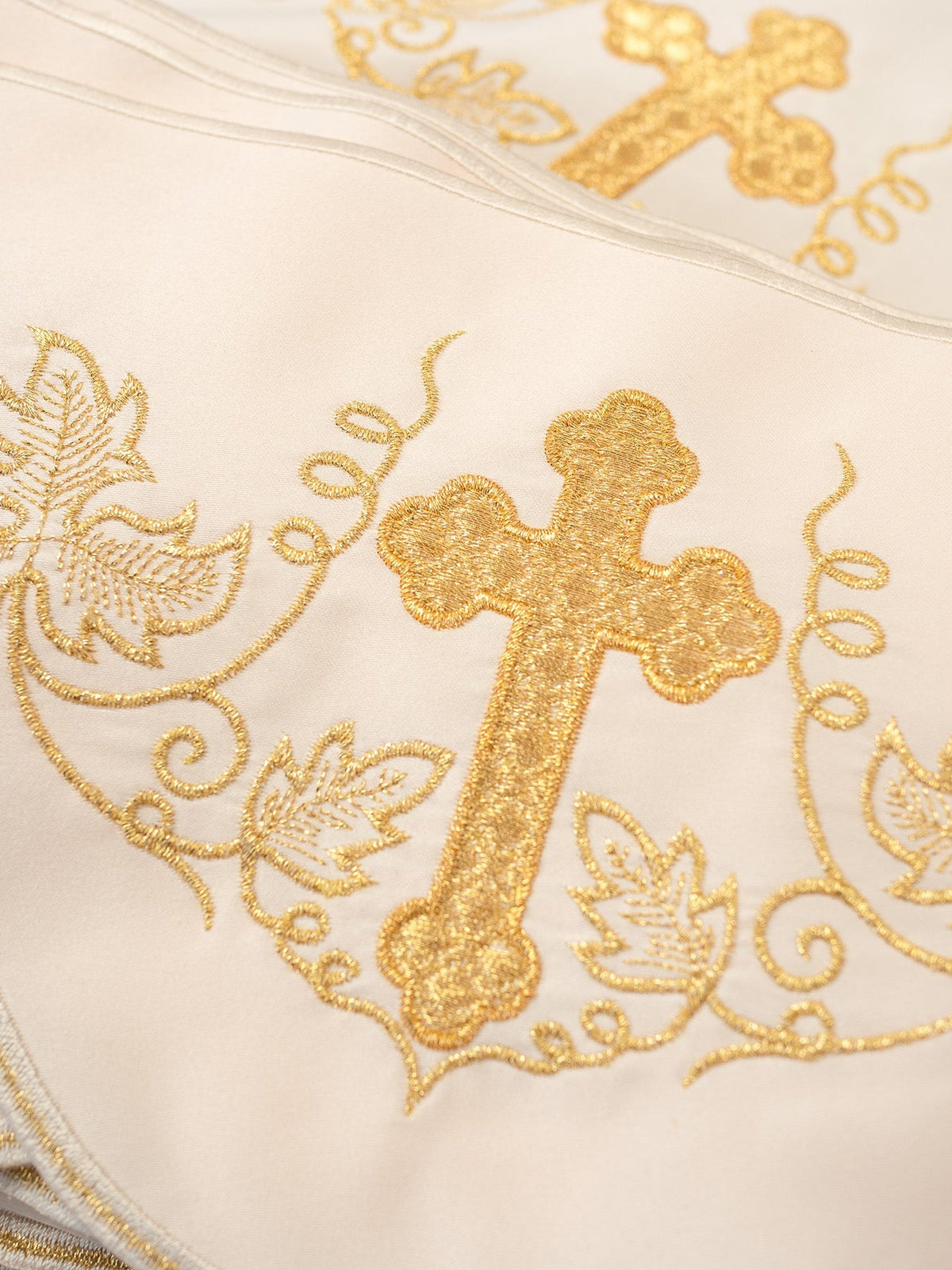 Altar lace close-up showing gold embroidery with a cross and grapevine motifs