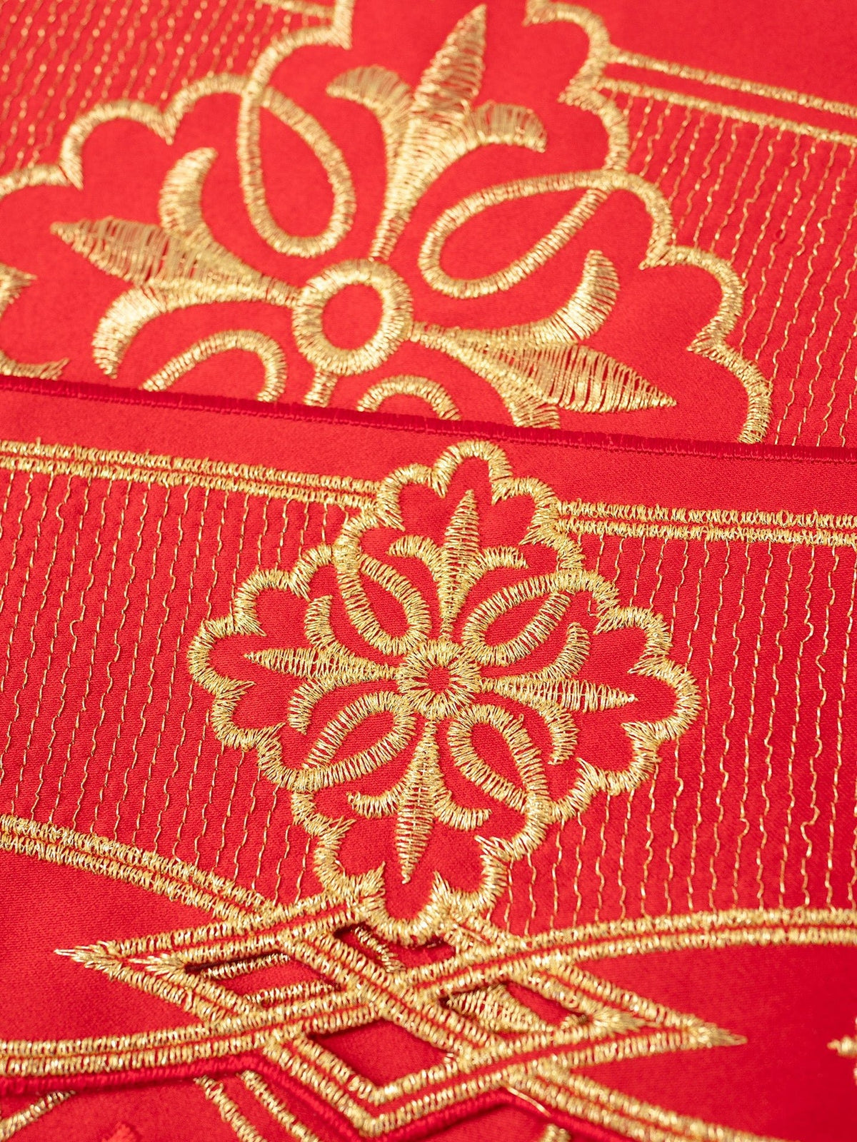 Red altar lace close-up showing gold rosette and Baratto-style embroidery