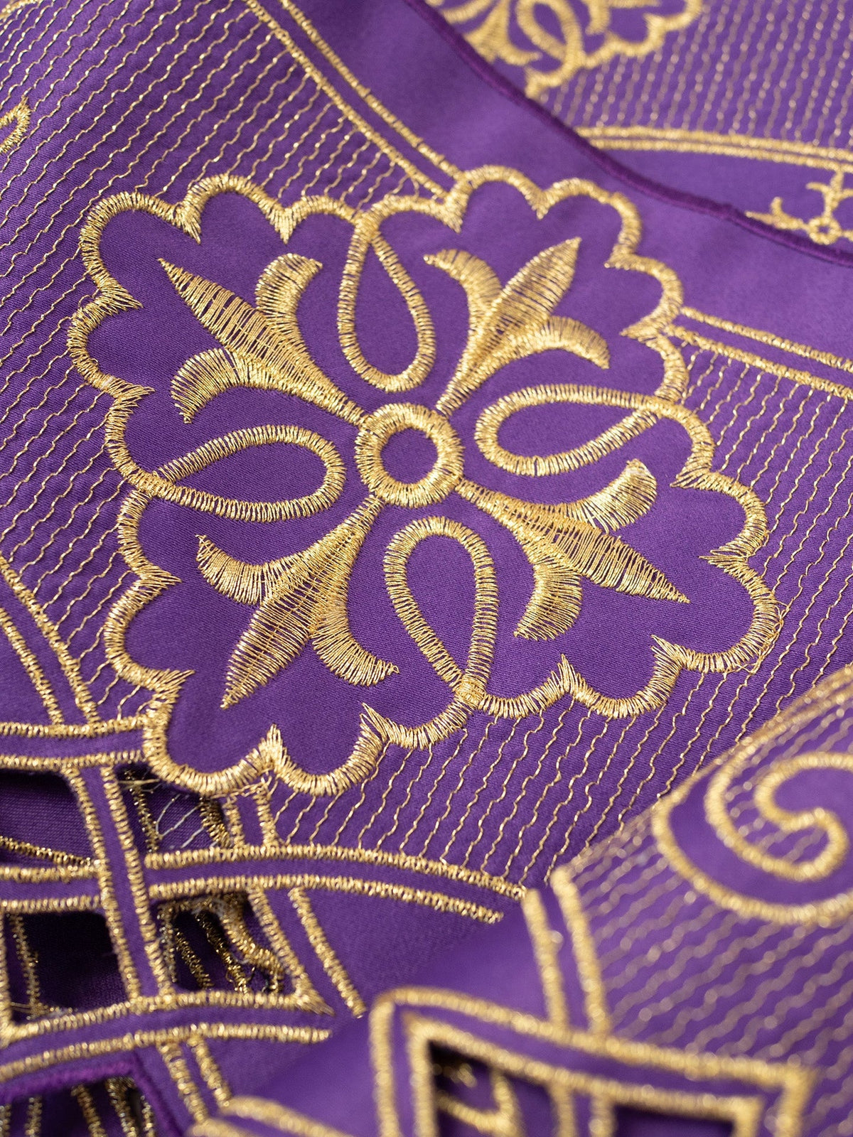 Purple altar lace close-up showing gold floral embroidery and fine vertical detailing